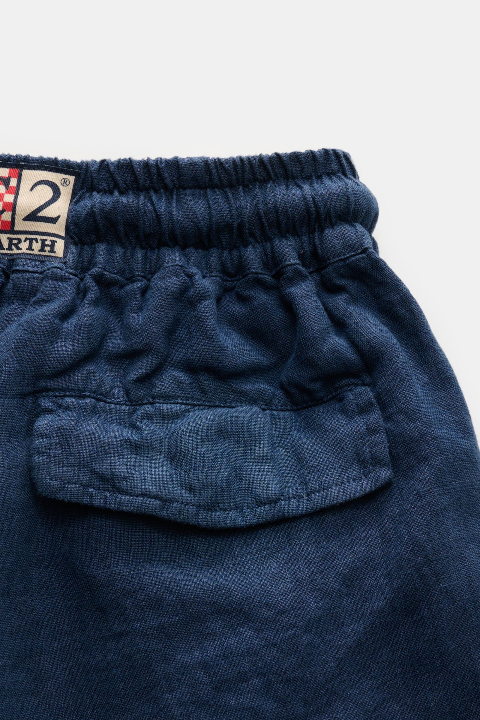 Back close-up view of MC2 Saint Barth Leinen Cargo-Shorts 'Marseille' navy, showing elastic waistband, garment-dyed linen fabric, tonal cargo pocket with flap, and distinctive woven label on back.