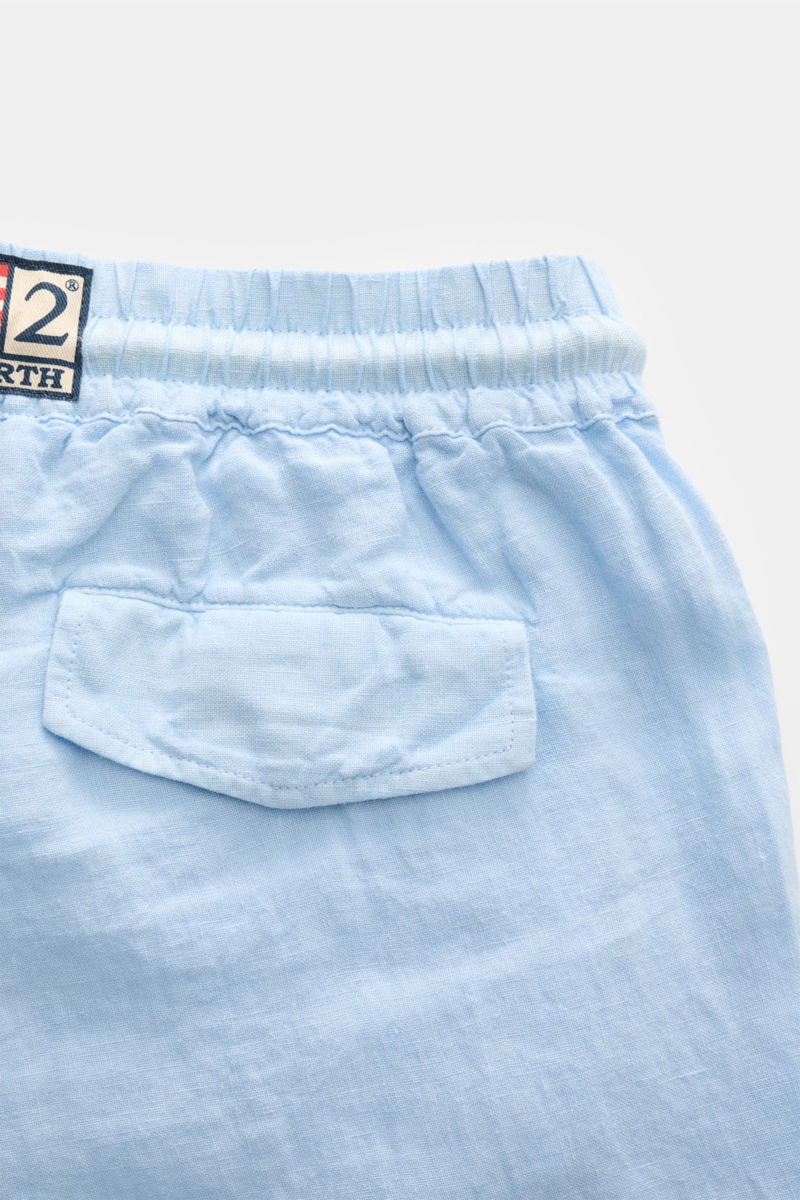 Nahaufnahme der Rückseite der MC2 Saint Barth Leinen Cargo-Shorts 'Marseille' hellblau mit elastischem Bund, Gesäßtasche und Weblabel, leichte Leinenstruktur.