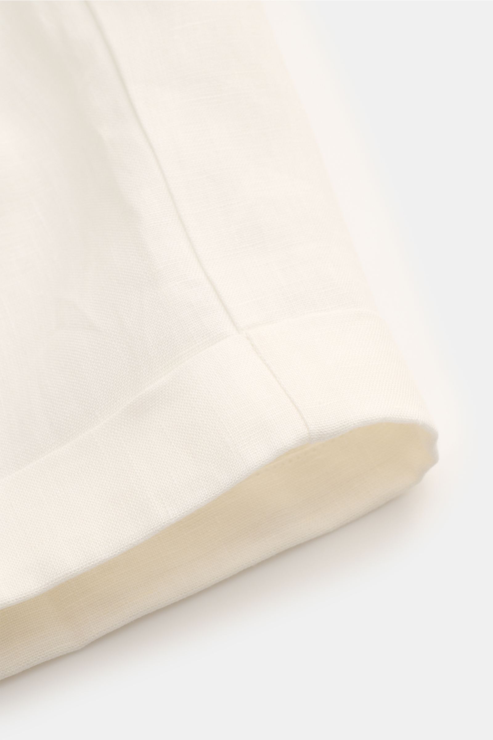 Nahaufnahme des fixierten Saumaufschlags der Aurélien Leinen-Shorts 'Seaside' offwhite aus reinem Leinen mit materialtypischer Struktur.