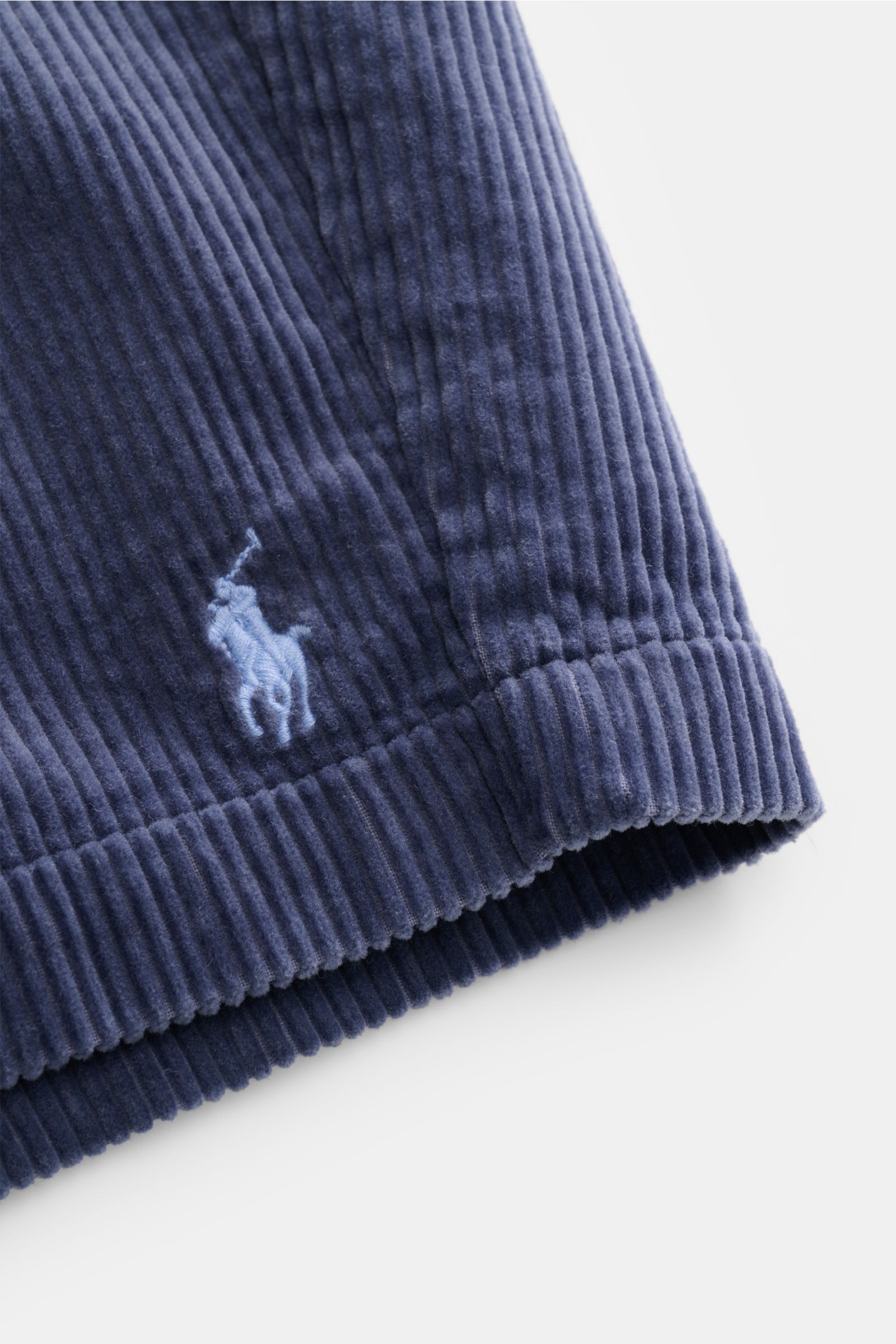 Nahaufnahme der Polo Ralph Lauren Cord-Shorts graublau aus reiner Baumwolle, weicher Griff, typische Cord-Struktur und Logo-Stickerei.