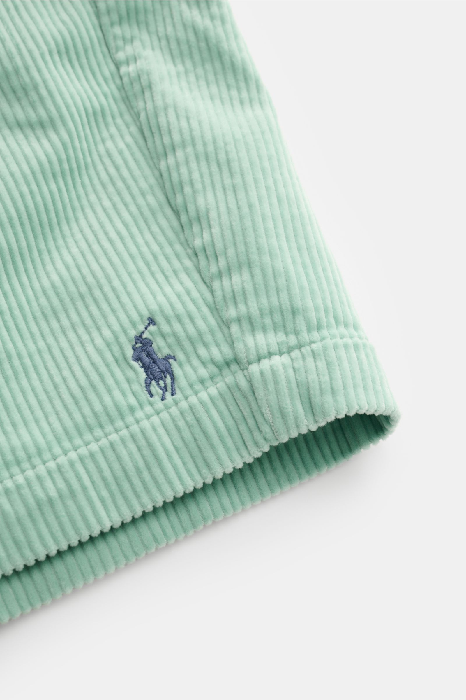 Nahaufnahme der Polo Ralph Lauren Cord-Shorts mint aus reiner Baumwolle, weicher Griff, typische Cord-Struktur, Detail der Logo-Stickerei, seitliche Perspektive.