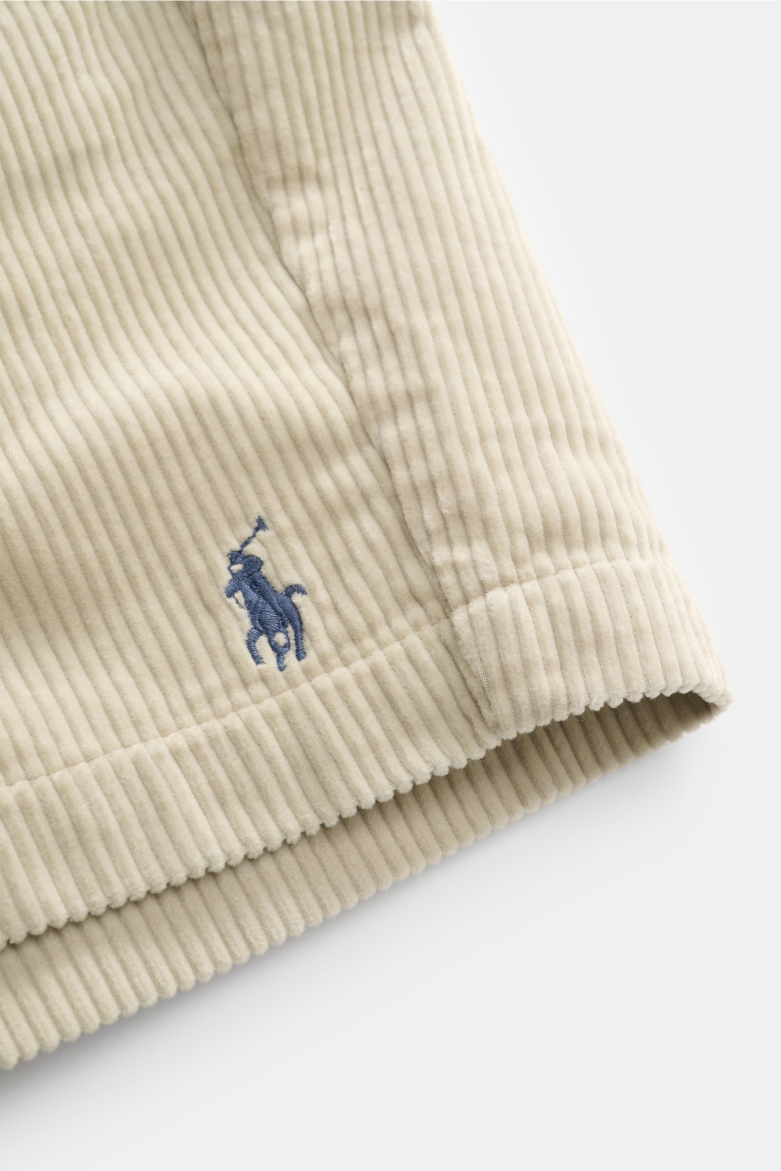 Nahaufnahme der Polo Ralph Lauren Cord-Shorts sand aus reiner Baumwolle, seitlich fotografiert, mit weichem Griff, Cord-Struktur und blauem Logo-Stick.