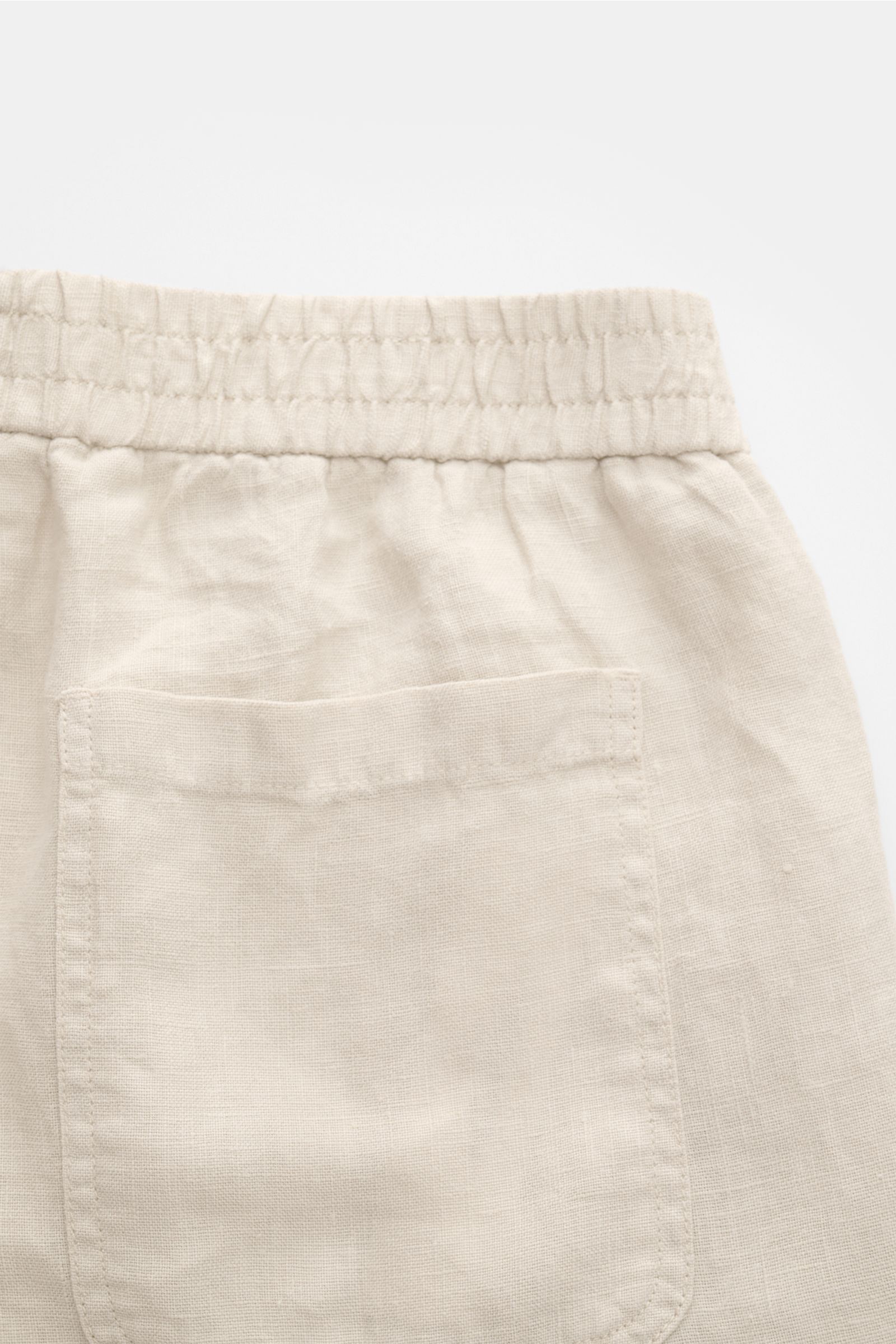 Nahaufnahme der Rückseite der 04651/ A trip in a bag Leinenshorts beige mit elastischem Bund, aufgesetzter Gesäßtasche und weichem Leinenstoff.