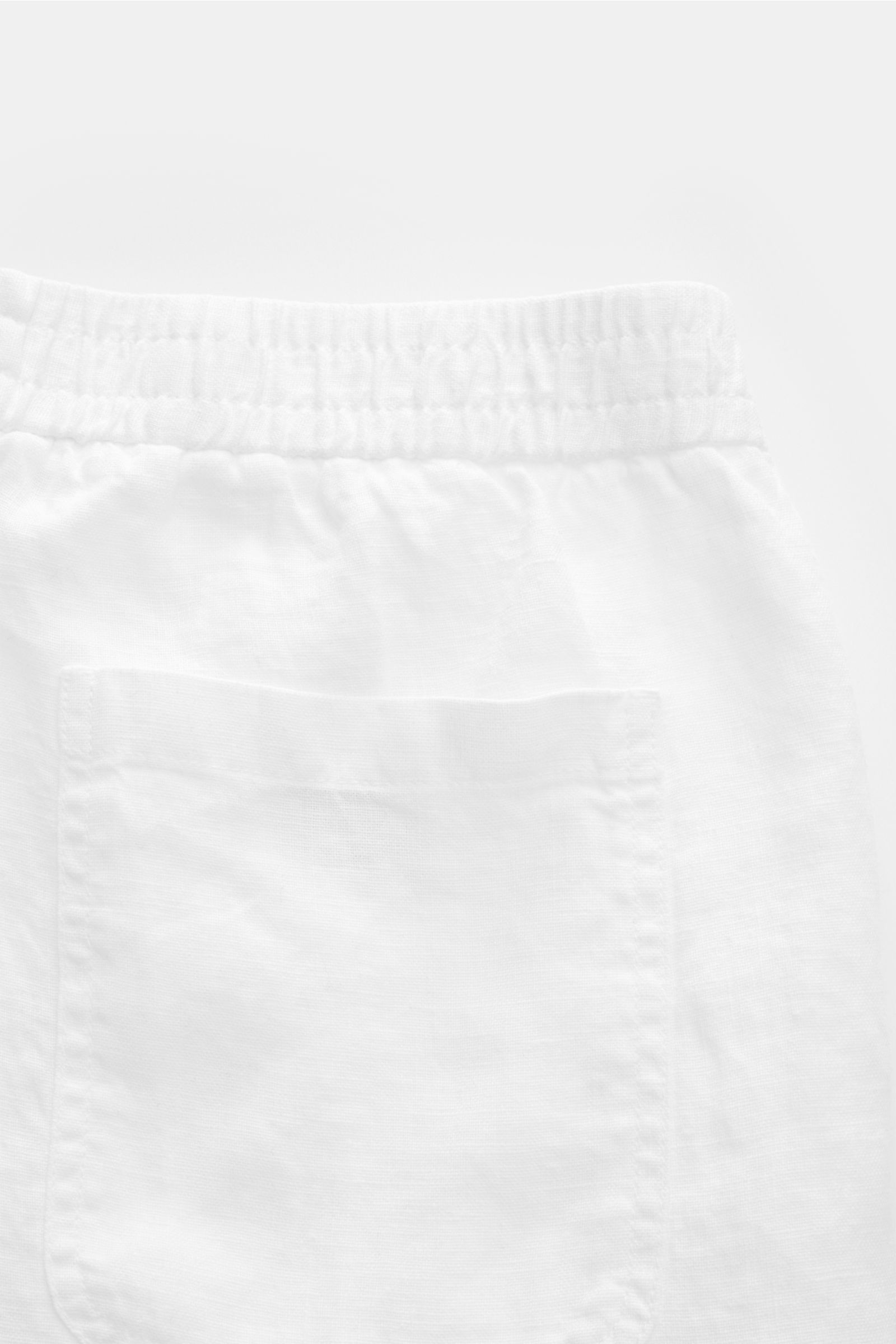 04651/ A trip in a bag Leinenshorts weiß, Detailaufnahme von hinten mit elastischem Bund, französischer Tasche und weichem Leinenstoff.