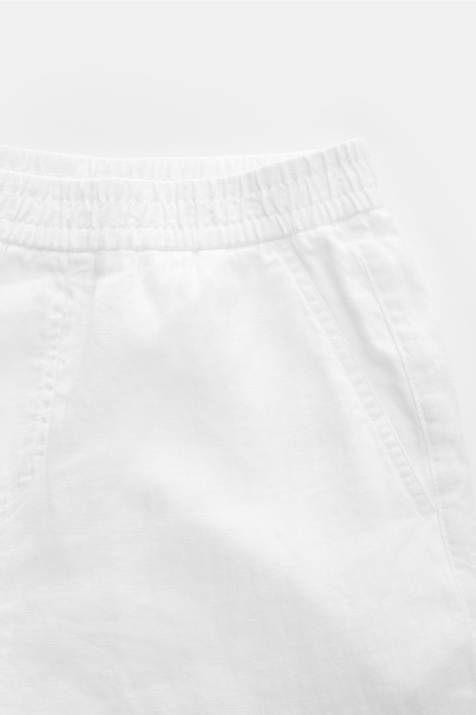 04651/ A trip in a bag Leinenshorts weiß, luftige weiße Shorts aus Leinen mit elastischem Bund, französischen Taschen, weichem Griff, garment dyed, Regular Fit, seitliche Nahaufnahme.