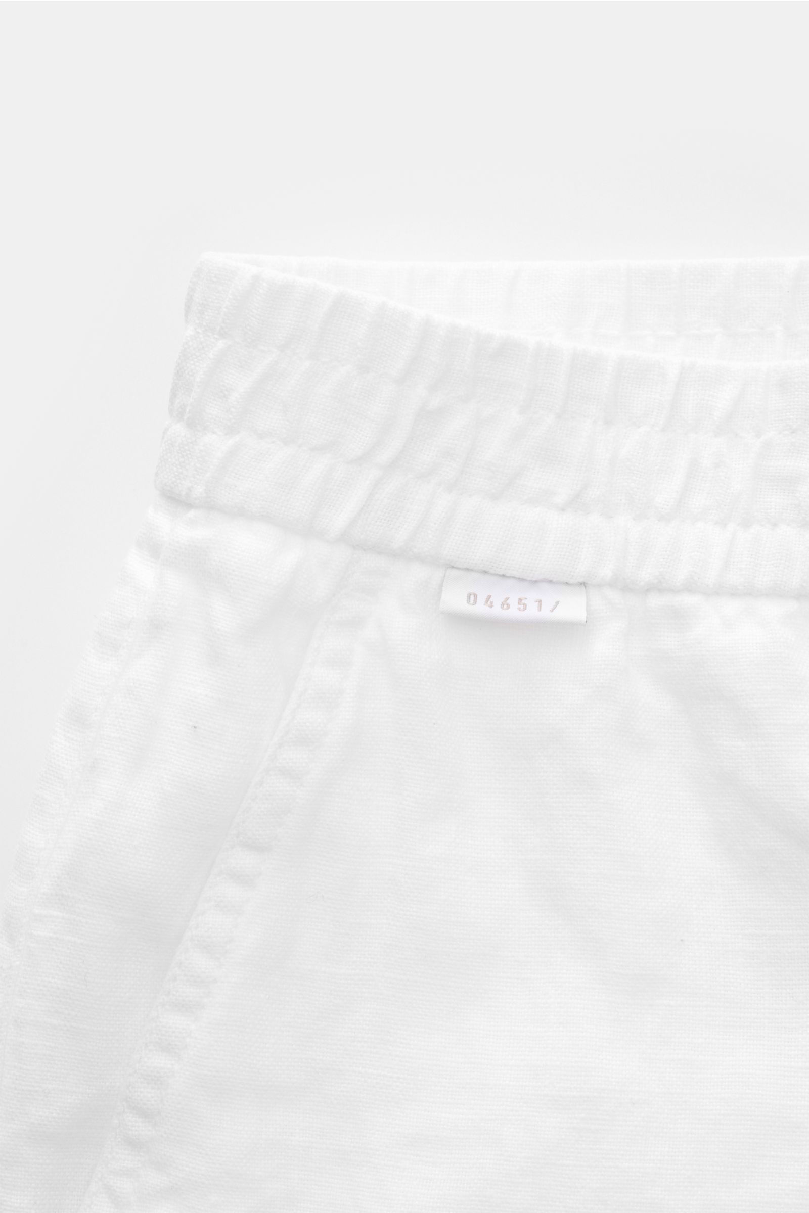04651/ A trip in a bag Leinenshorts weiß, Nahaufnahme von elastischem Bund, französischer Tasche und kleinem Weblabel, luftiges Leinenmodell.