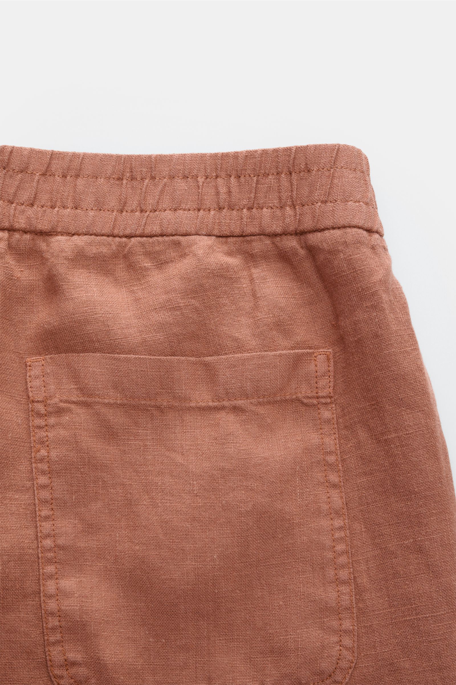 Nahaufnahme der 04651/ A trip in a bag Leinenshorts rostbraun von hinten, elastischer Bund, aufgesetzte Gesäßtasche, weiches Leinen.