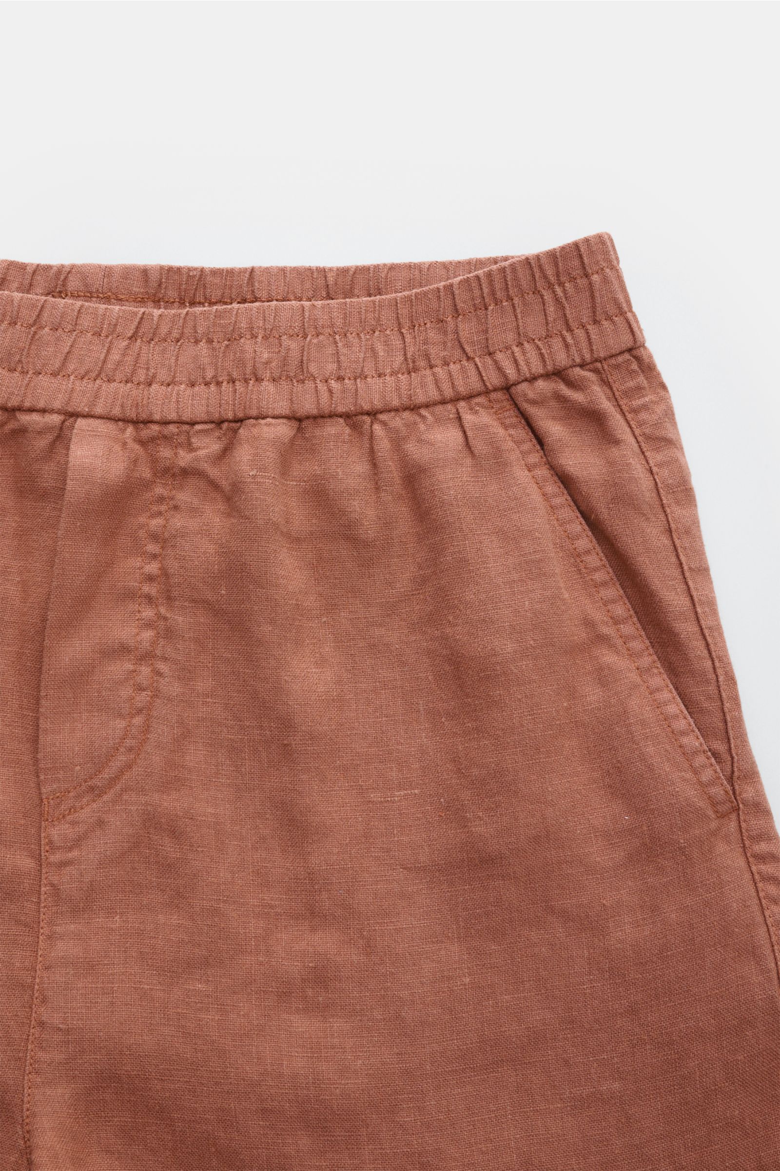 04651/ A trip in a bag Leinenshorts rostbraun, Detailfoto von vorne oben, elastischer Bund, französische Taschen, weiches, luftiges Leinen, garment dyed.