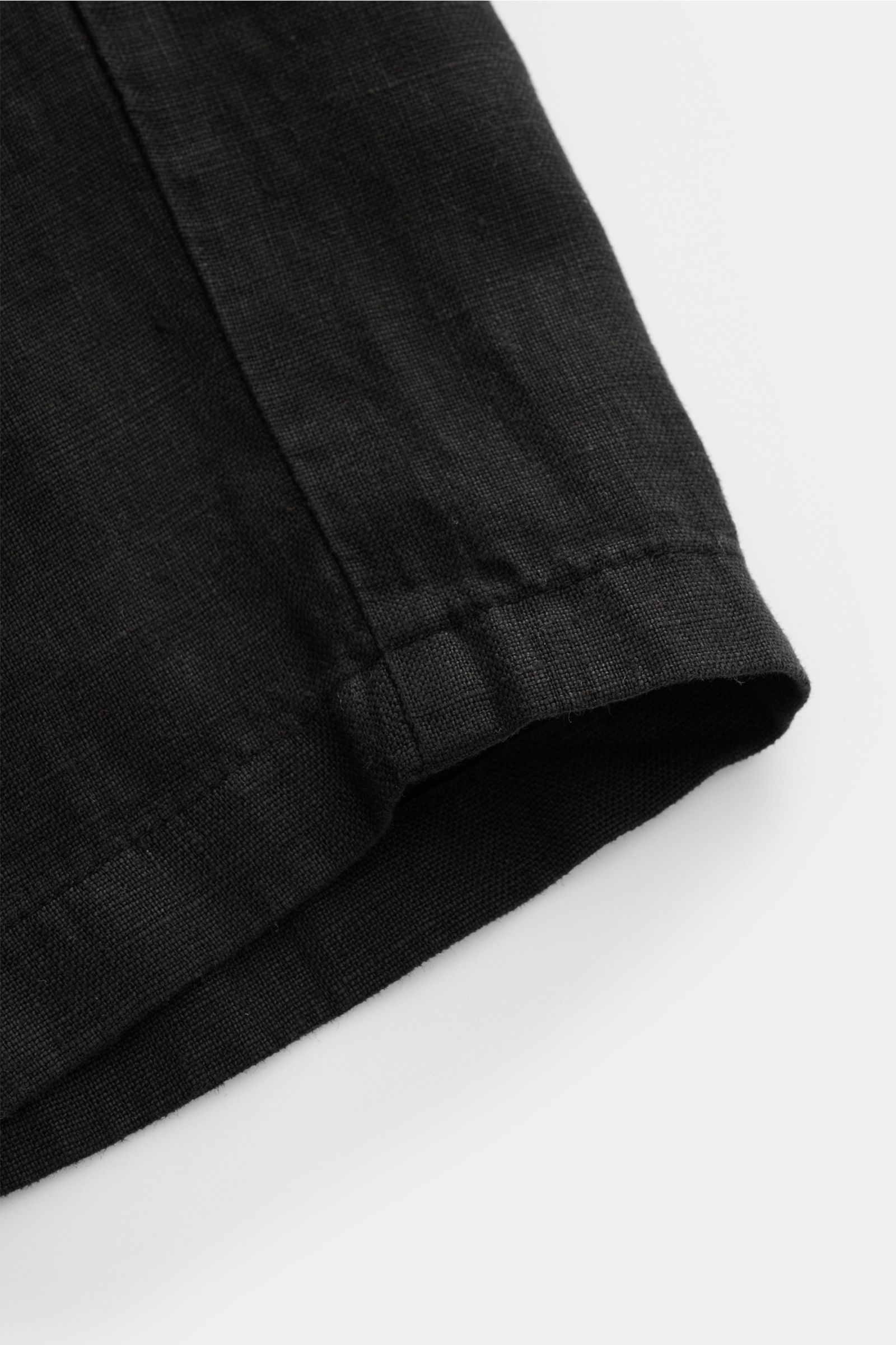 Close-up view of black linen shorts hem, showcasing fine texture and neat stitching of 04651/ A trip in a bag Linen shorts black.

Description: With this airy model, 04651/ A TRIP IN A BAG presents a comfortable pair of pure linen shorts that are the p
