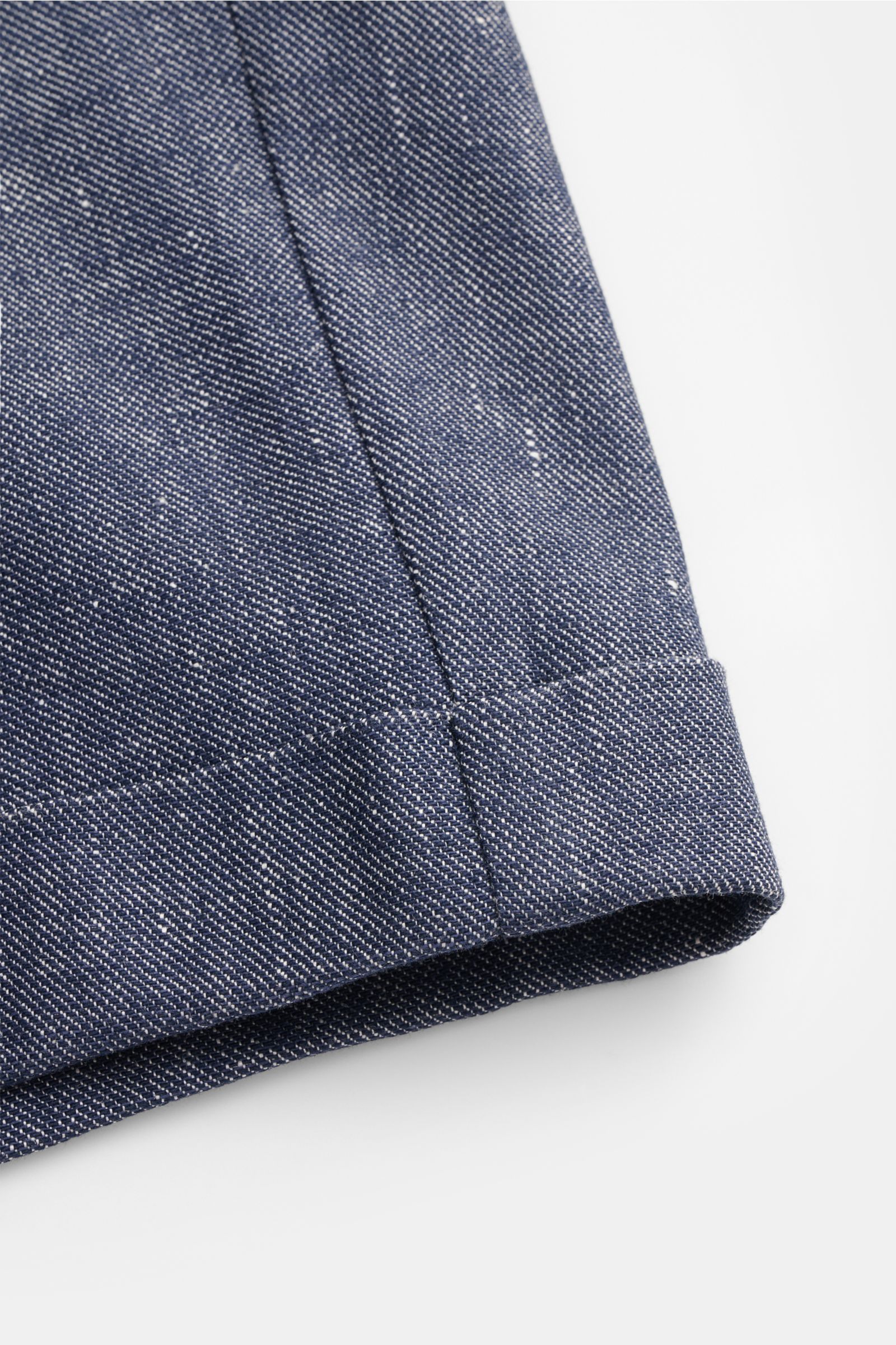 Nahaufnahme der fixierten Saumaufschläge der 04651/ A trip in a bag Shorts navy aus leicht griffigem Leinen-Baumwoll-Denim, fotografiert von unten.