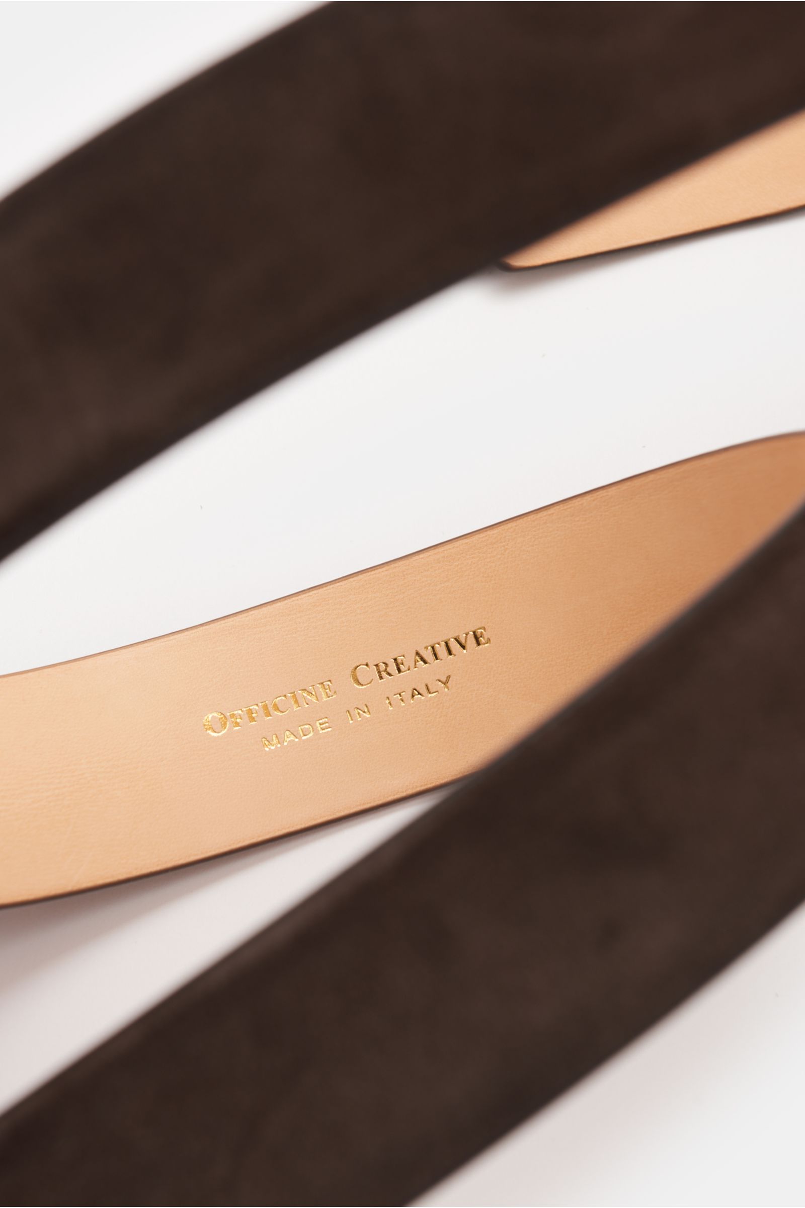 Officine Creative Gürtel dunkelbraun aus edlem Veloursleder, geschmeidiger Griff, Dornschließe Messing, zwei Durchzugschlaufen, Made in Italy, 3,5 cm breit, Nahaufnahme von oben.