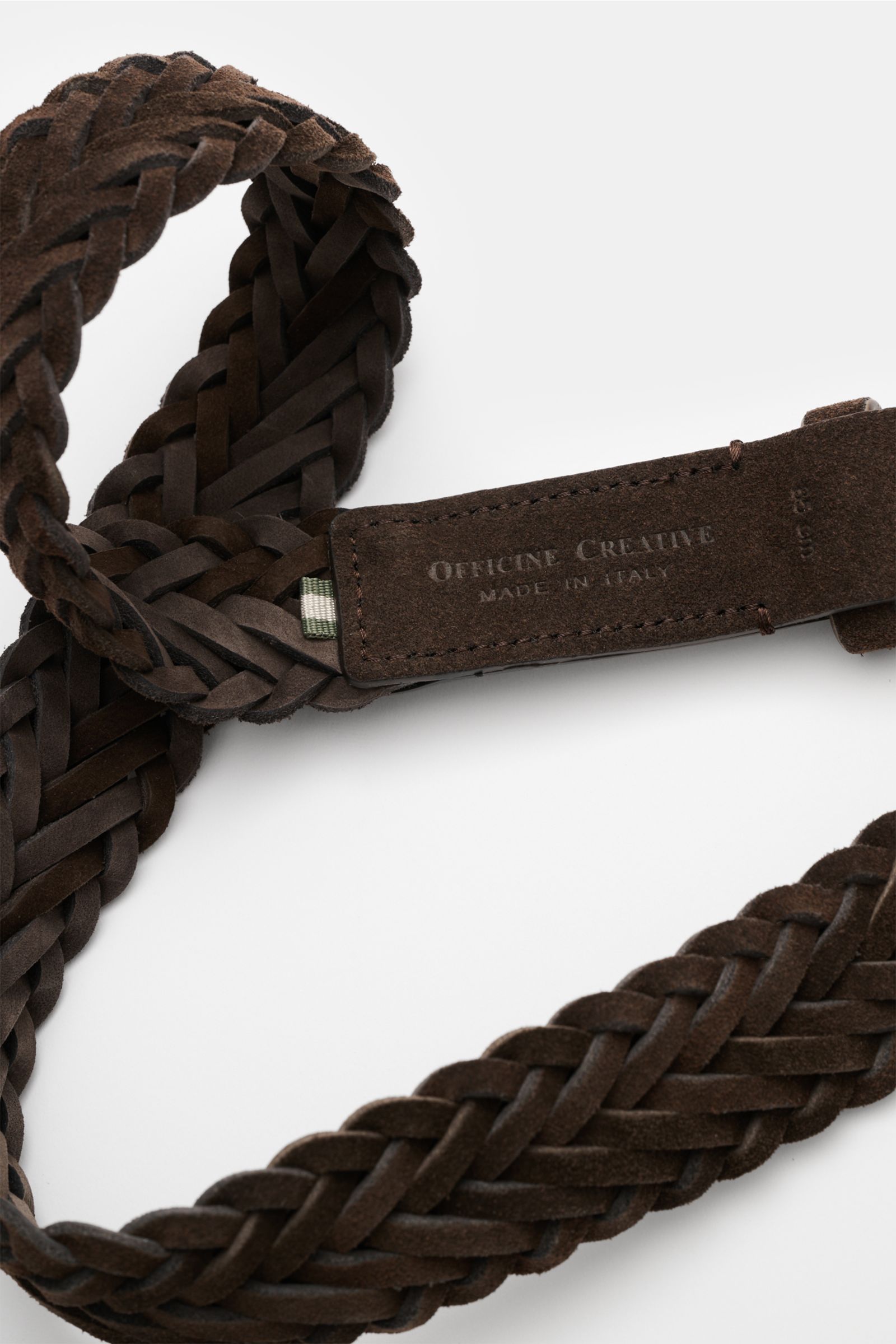 Officine Creative Flechtgürtel dunkelbraun aus edlem Veloursleder, schmal, geflochten, silberne Dornschließe, stufenlos verstellbar, Nahaufnahme von oben.