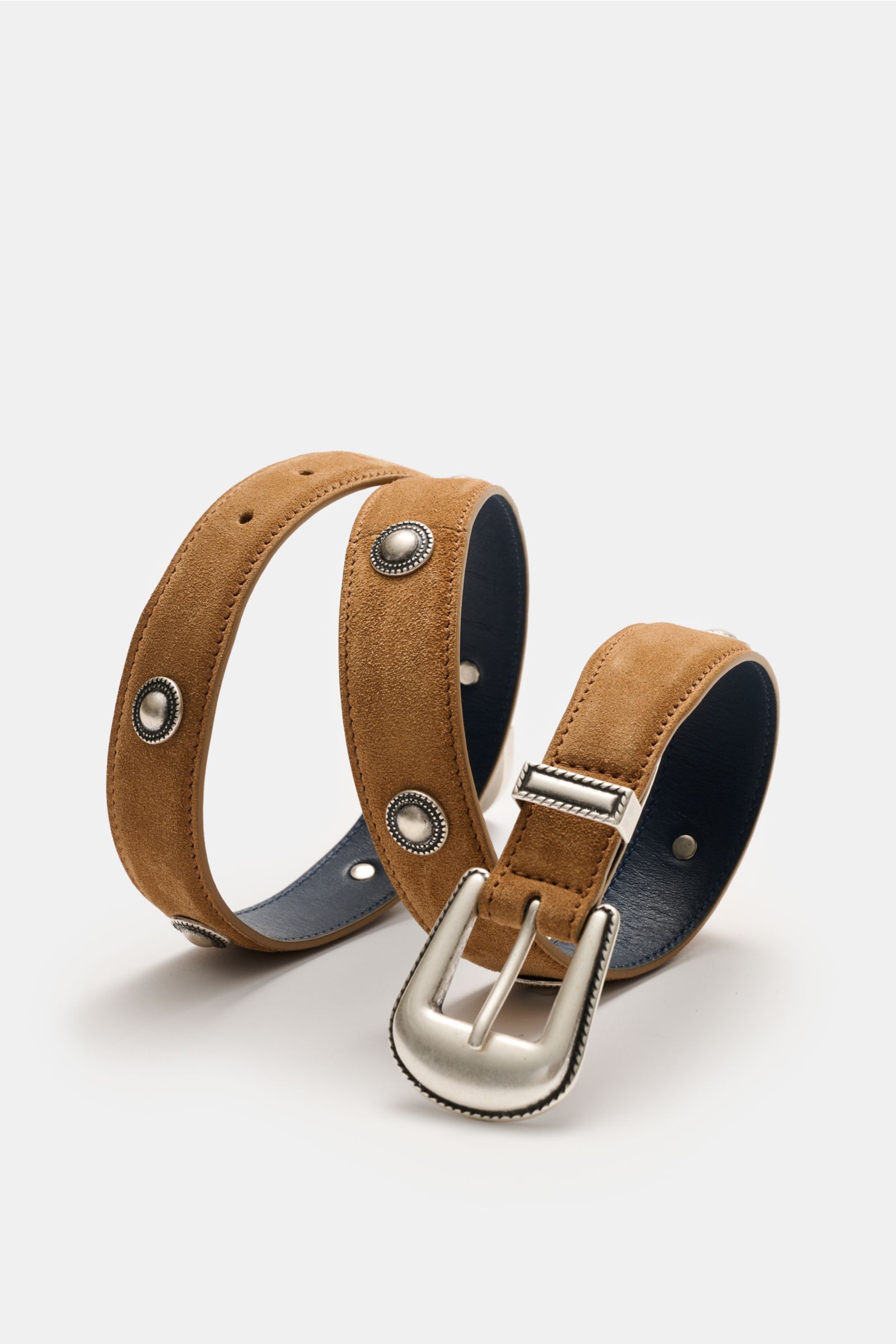 Close-up front-side view of Ace Denim Veloursleder Gürtel 'Cowboy Belt' hellbraun, a soft suede light brown belt with silver Western-style conchos, decorative metal tip, silver buckle, and metal belt loop, made in Italy, approx. 2.5 cm wide.