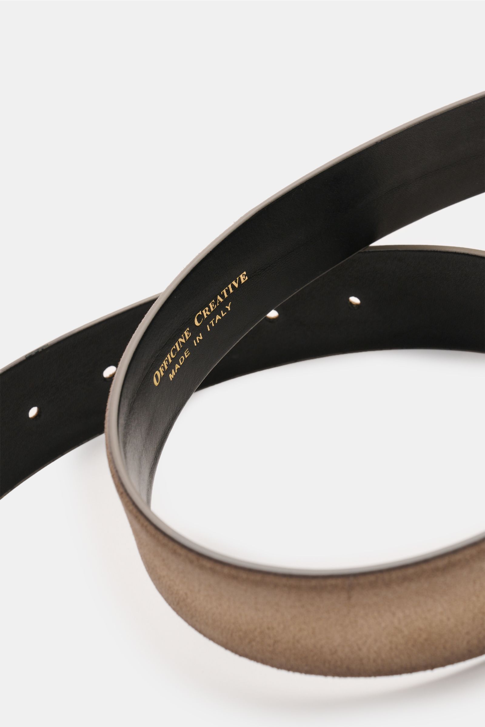 Close-up top-down view of Officine Creative Gürtel taupe made of soft taupe velour leather, showing black inner lining with gold logo.

Description: Stilvoller Klassiker: Mit seinem zeitlosen Design wird der Veloursledergürtel von OFFICINE CREATIVE zum