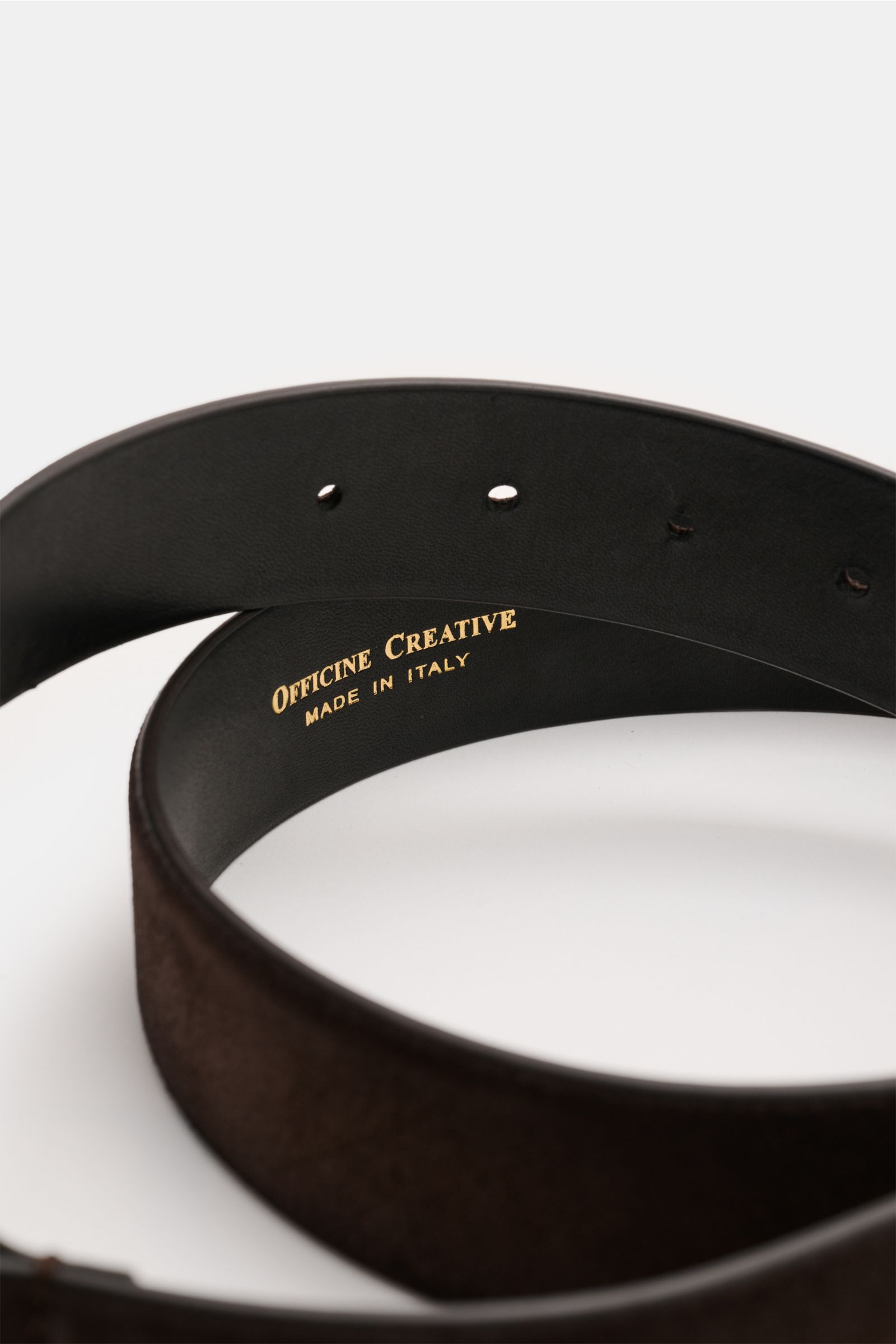 Close-up side view of the Officine Creative Gürtel dunkelbraun made of elegant dark brown velour leather with brass buckle and two loops.

Stilvoller Klassiker: Mit seinem zeitlosen Design wird der Veloursledergürtel von OFFICINE CREATIVE zum eleganten