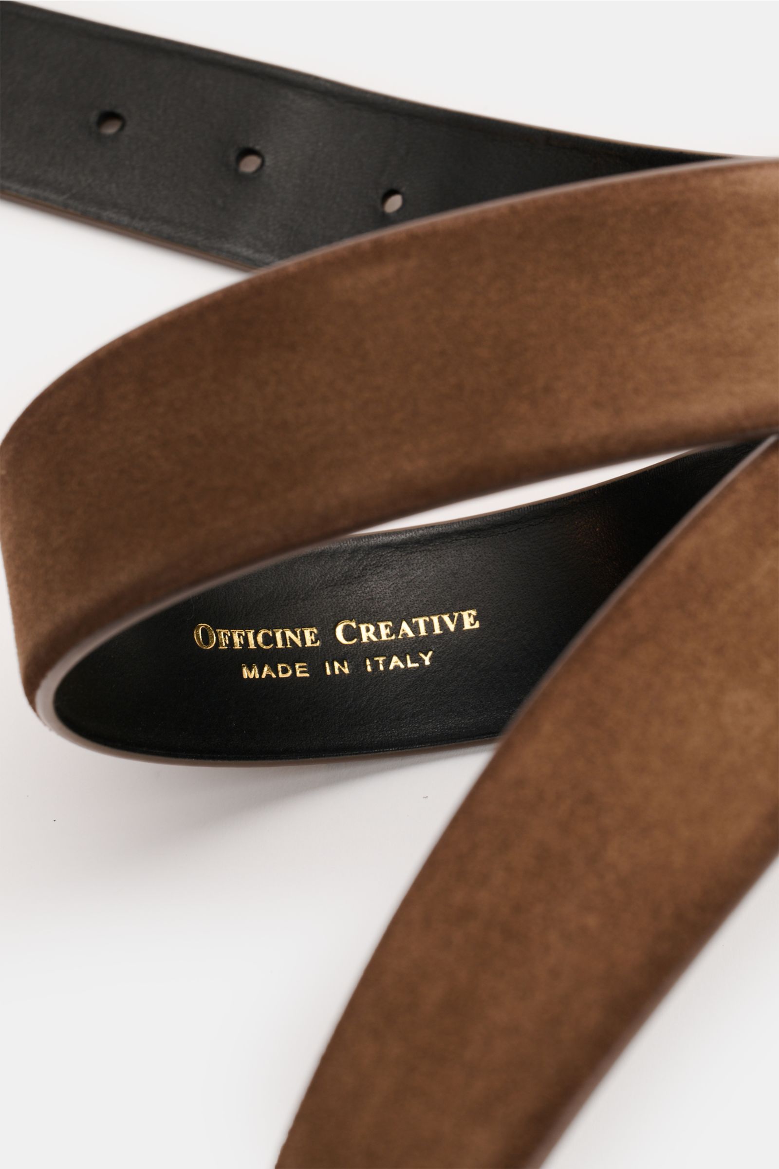 Close-up top view of the Officine Creative Gürtel braun made of elegant brown velour leather with black inner lining and gold logo.

Description:  
Stilvoller Klassiker: Mit seinem zeitlosen Design wird der Veloursledergürtel von OFFICINE CREATIVE zum 