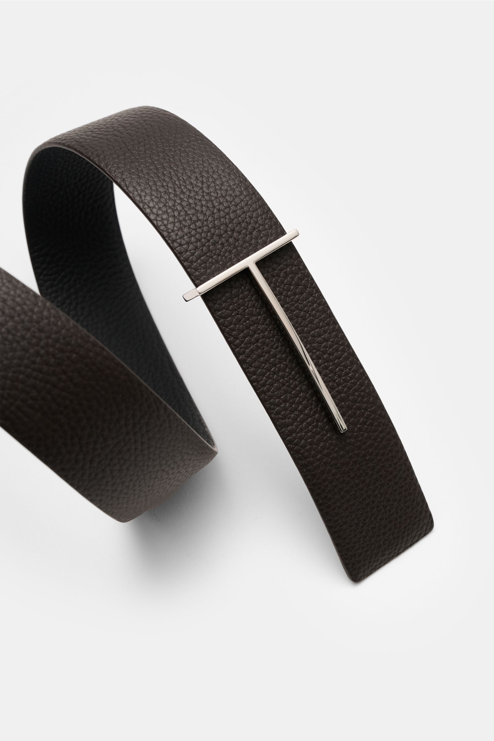 Close-up top view of Tom Ford Gürtel schwarz/dunkelbraun made of edles Kalbleder with charakteristische Narbung, silver brass T-shaped buckle, wendbar design, approx. 3.5 cm wide, Made in Italy. Eleganter Eyecatcher: Mit seinem zeitlosen Look wird der TOM