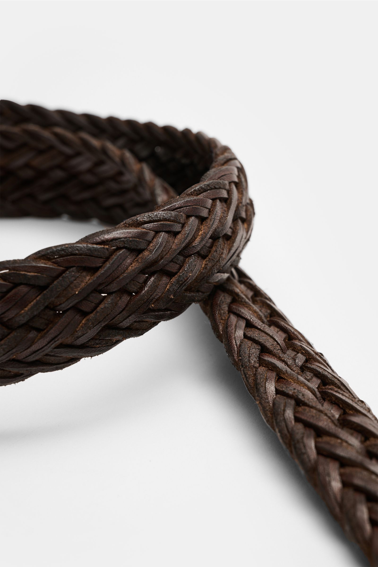 Orciani Flechtgürtel dunkelbraun aus edlem Rindsleder mit Dornschließe, Durchzugsschlaufe, ca. 3 cm breit, Nahaufnahme schräg oben.