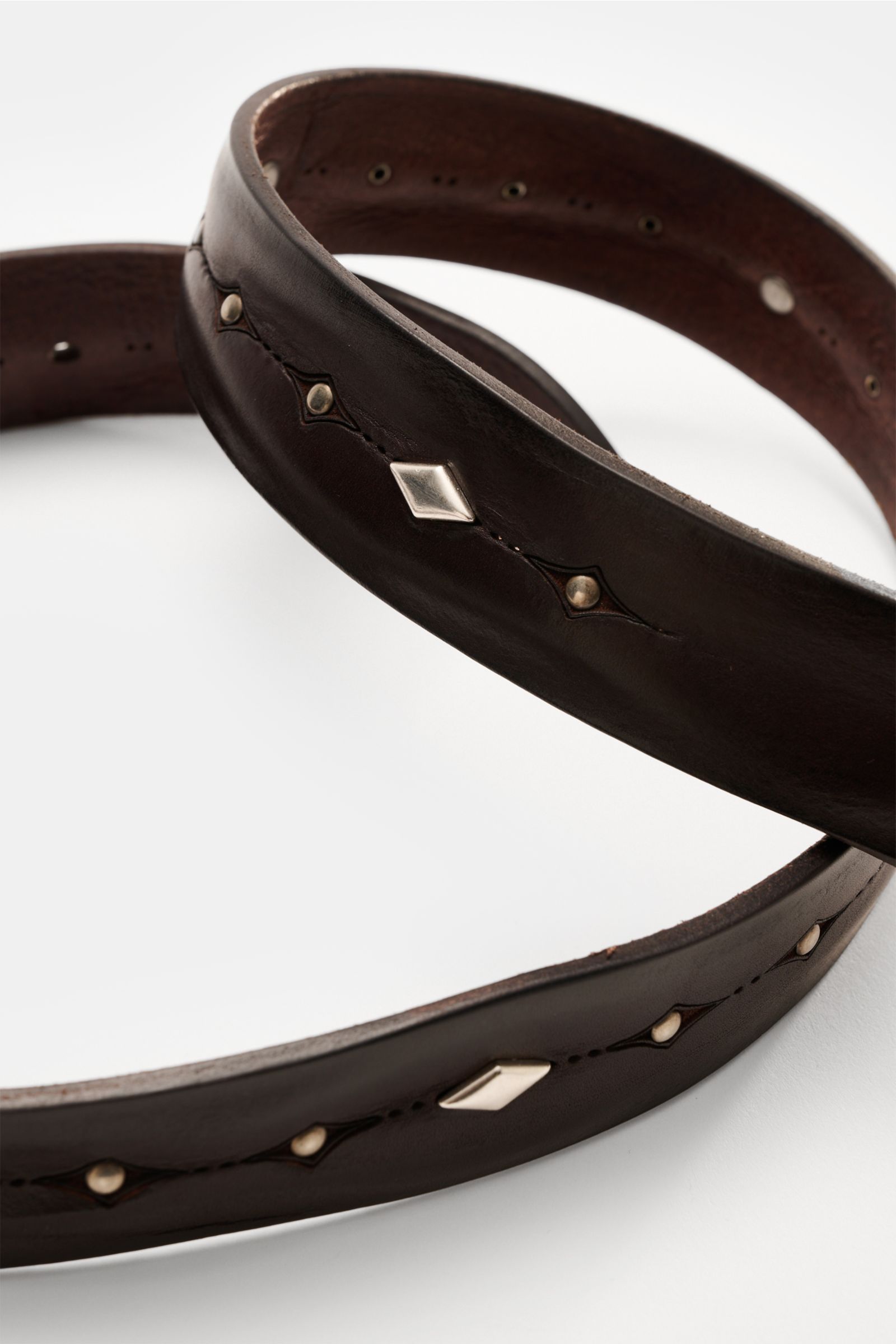 Close-up angled view of Orciani Gürtel dunkelbraun, a luxurious vintage-style leather belt with stud design, brass buckle, and 3.5 cm width. Luxuriöser Eyecatcher im vintage Look: Der Nietengürtel von ORCIANI aus edlem Leder wird mit seinem Western-Design