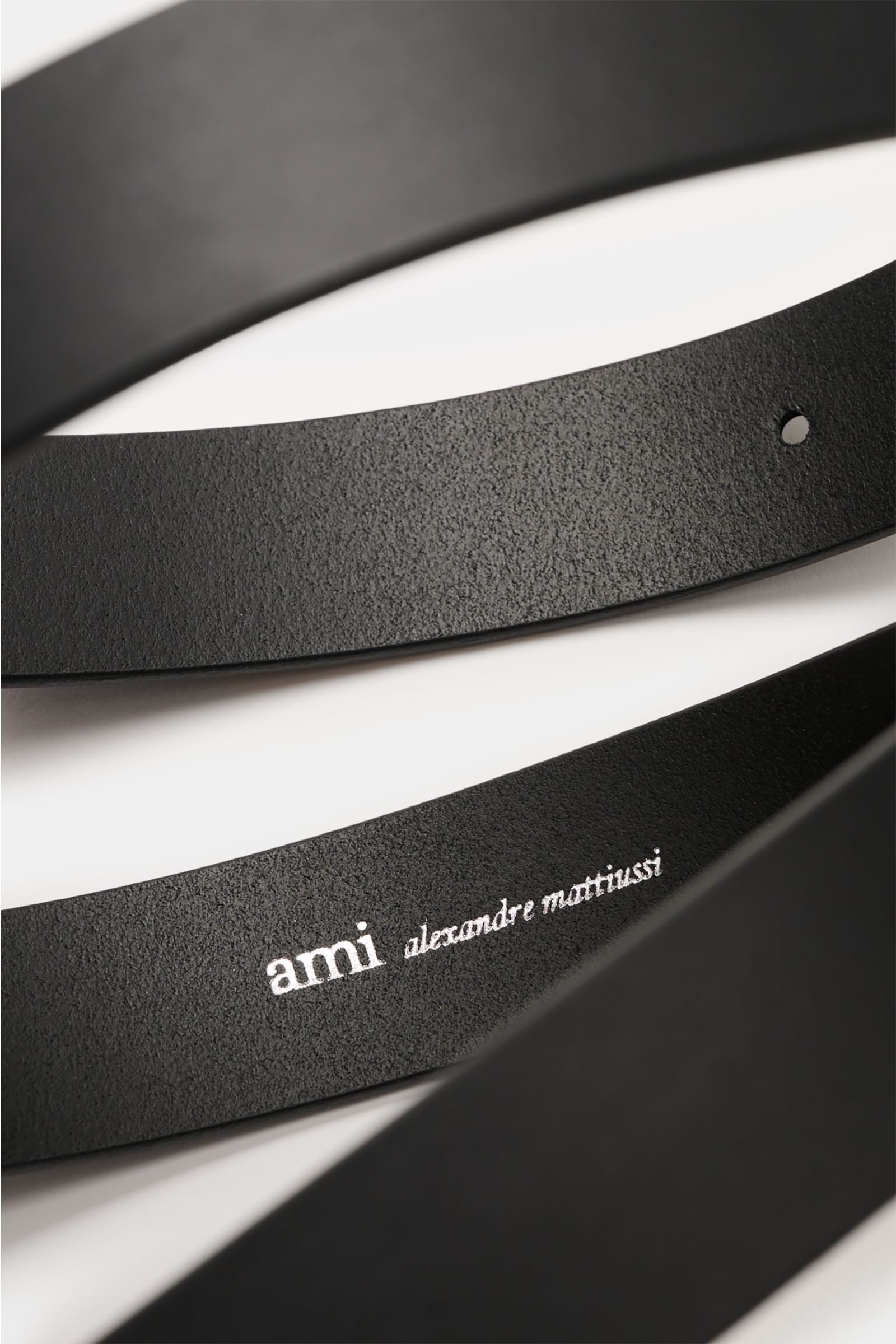 Close-up top view of the Ami Paris Gürtel 'Paris' schwarz, a black smooth leather belt showing the embossed logo and texture.

Zeitloses Accessoire: Der 'Paris' Gürtel von AMI PARIS erweist sich als vielseitiges Essential für stilvolle Outfits.
