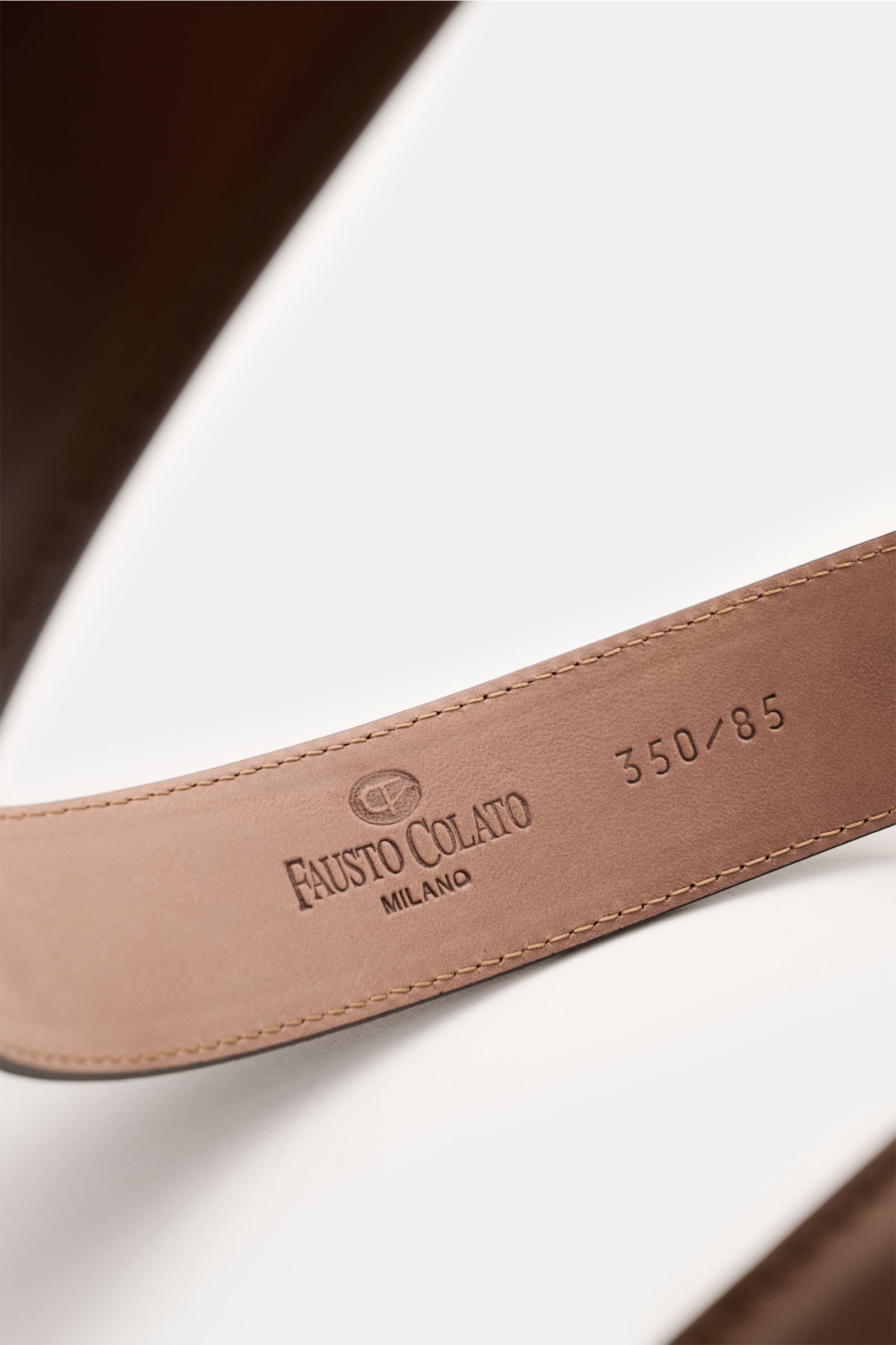 Nahaufnahme des braunen Fausto Colato Gürtel aus edlem Glattleder, Detailansicht der Prägung, gefertigt in Italien mit Messing-Dornschließe und Durchzugschlaufe.