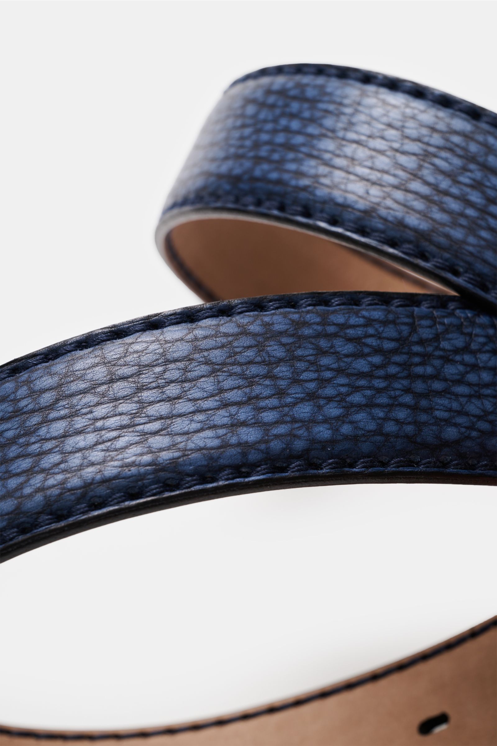 Nahaufnahme aus schräger Perspektive des Fausto Colato Gürtel Bisonleder dunkelblau, aus glattem Bisonleder mit Dornschließe aus Messing, einer Durchzugschlaufe, Made in Italy, luxuriös und praktisch.