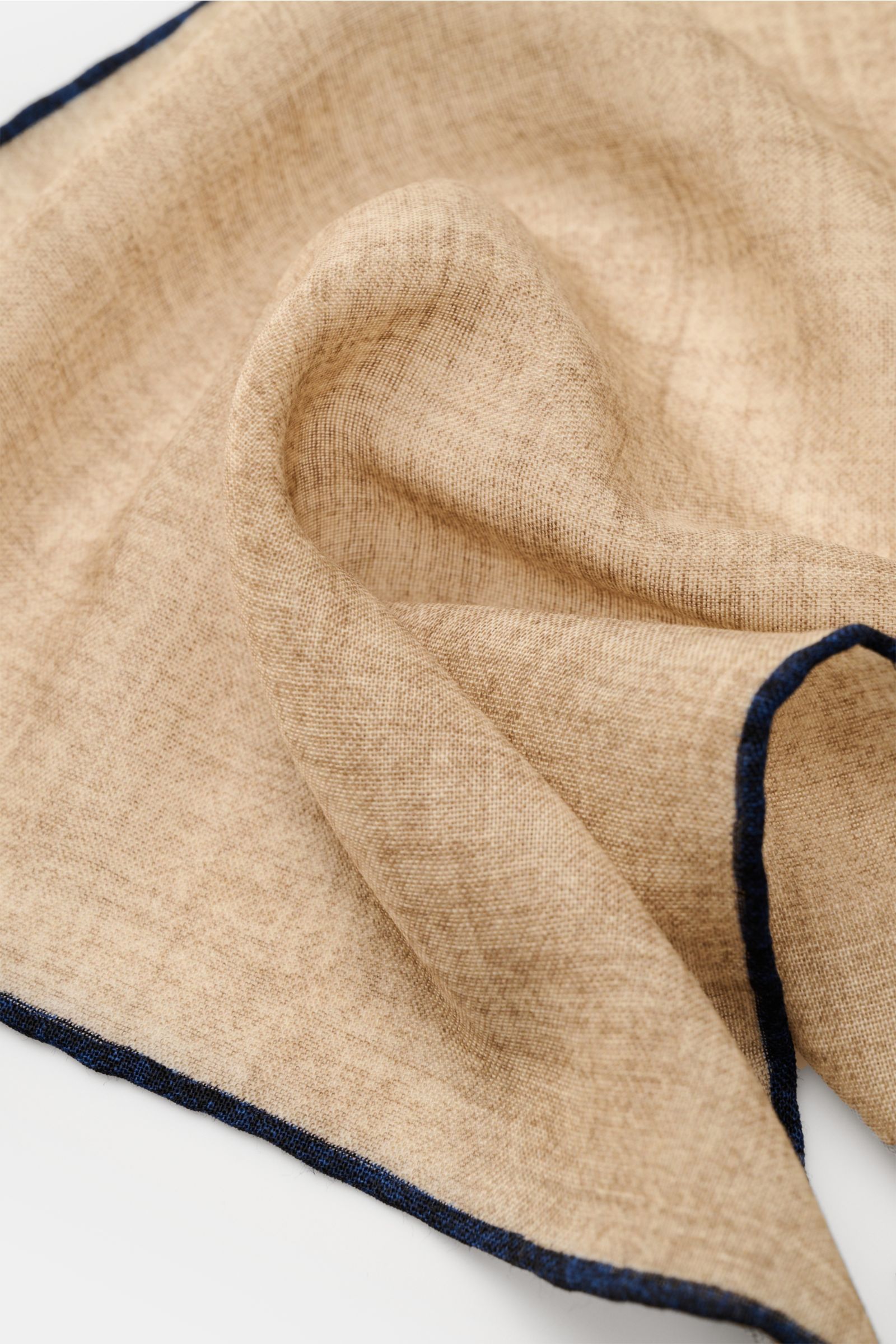 Rosi Collection Einstecktuch beige/navy aus reiner Wolle, weicher Griff, handrollierte Kanten in Kontrastfarbe, Made in Italy, ca. 30x30 cm, Detailaufnahme von schräg oben.