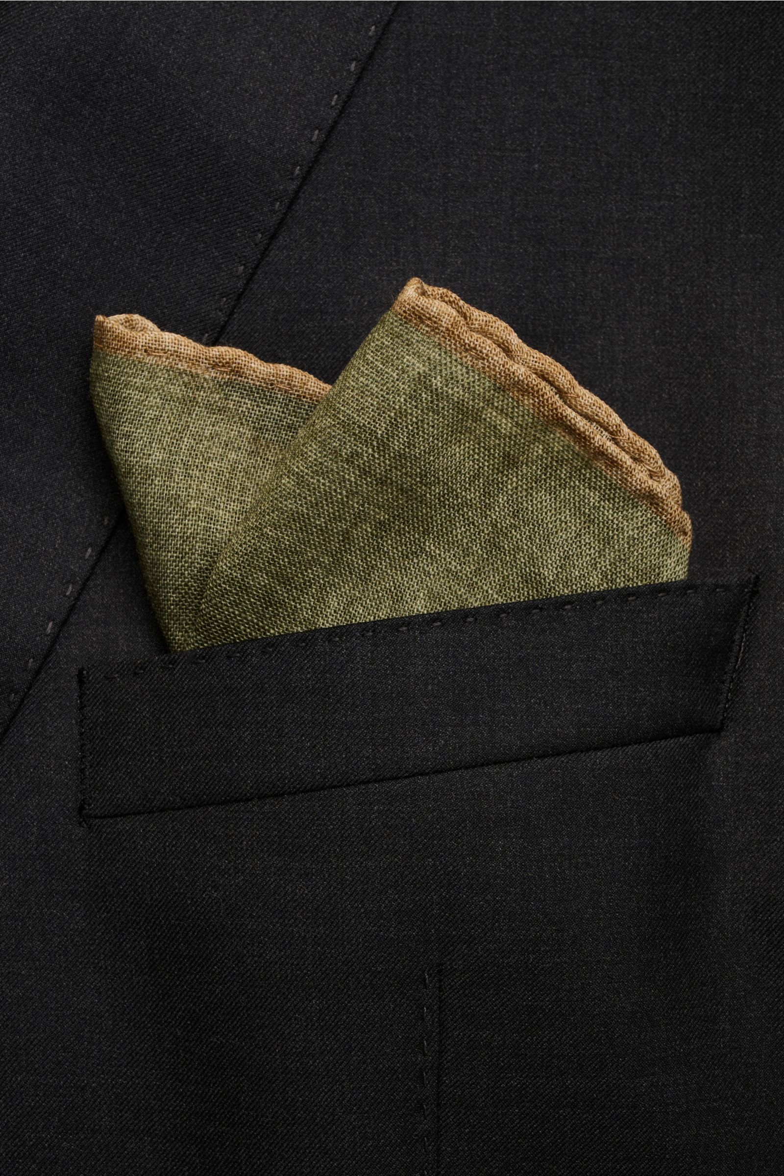 Rosi Collection Einstecktuch oliv/beige aus reiner Wolle, handrollierte Kanten, weicher Griff, ca. 30x30 cm, Made in Italy, frontale Nahaufnahme im Sakko-Taschenfach.