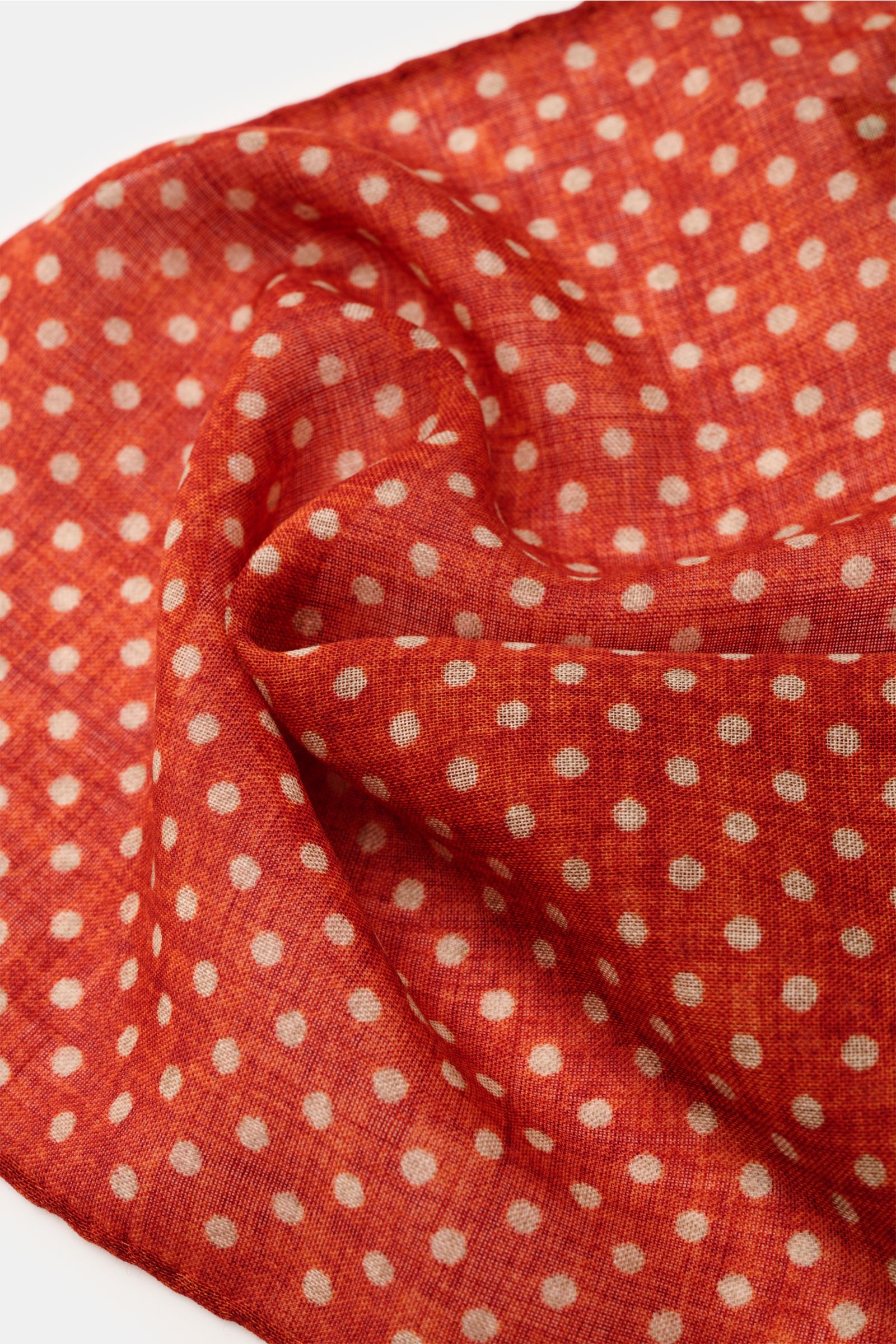 Rosi Collection Einstecktuch rostbraun/beige gepunktet aus reiner Wolle, weicher Griff, grafisches Punktmuster, handrollierte Kanten, Made in Italy, ca. 29x29 cm, Nahaufnahme von schräg oben.