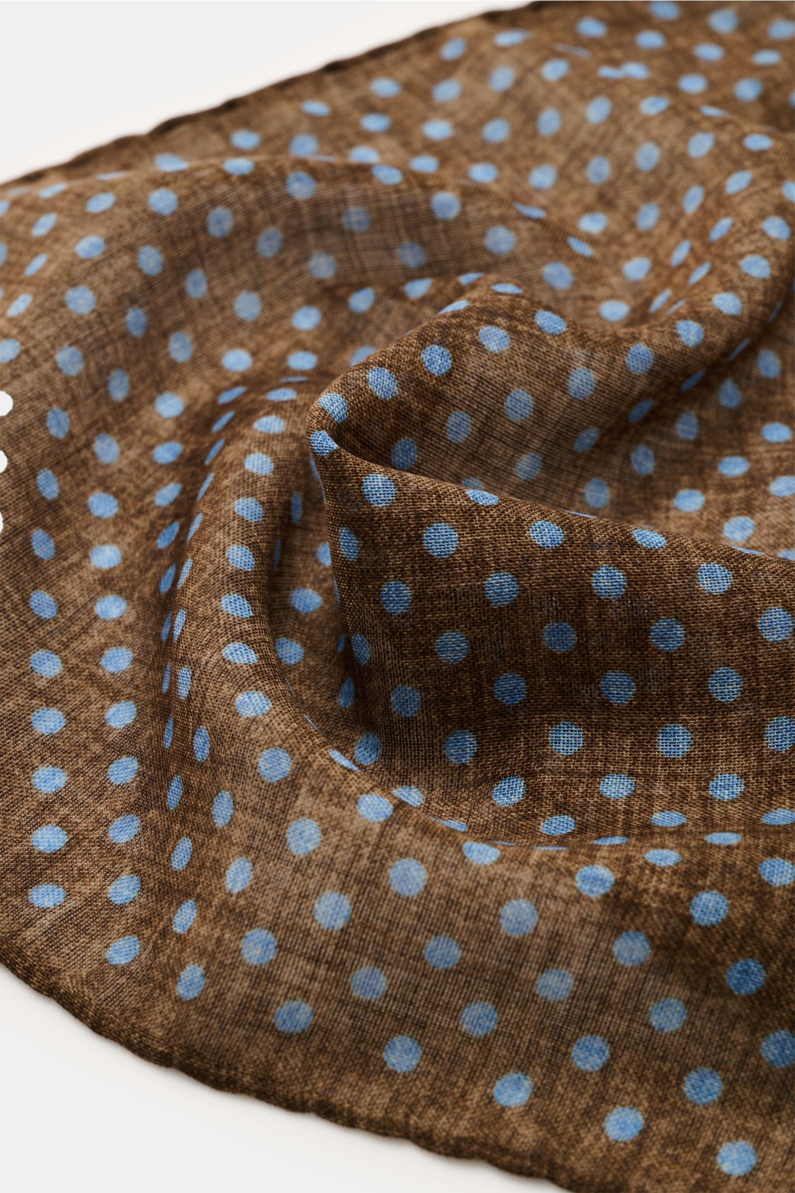 Rosi Collection Einstecktuch braun/rauchblau gepunktet, reine Wolle, weicher Griff, grafisches Punktmuster, handrollierte Kanten, Made in Italy, ca. 29x29 cm, Nahaufnahme von oben.