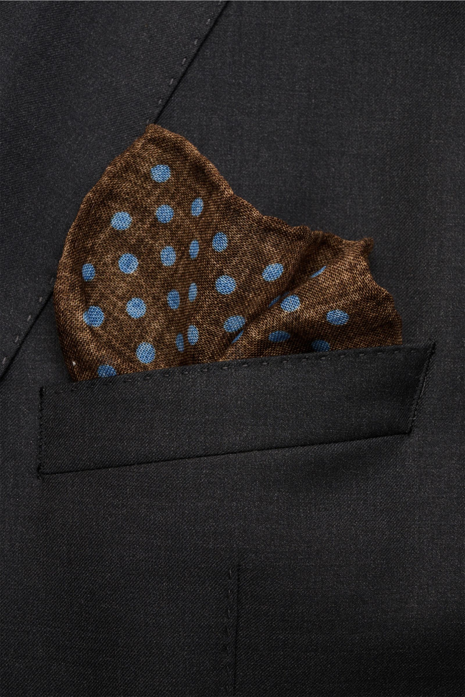 Rosi Collection Einstecktuch braun/rauchblau gepunktet aus reiner Wolle mit weichem Griff, grafischem Muster, handrollierten Kanten, Made in Italy, ca. 29x29 cm, frontal in Anzugtasche.