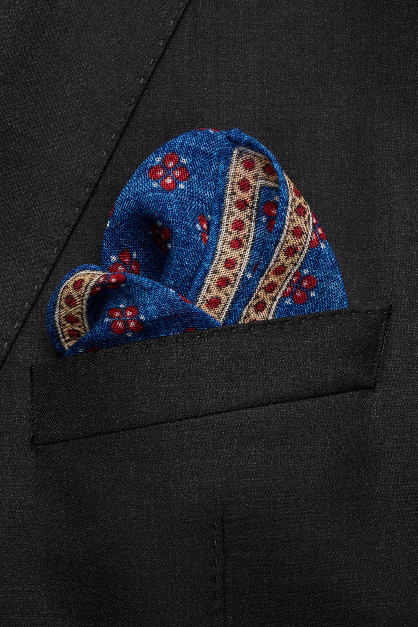 Close-up front view of the Rosi Collection Pocket square 'Ted' blue mottled/red/beige patterned tucked into a black jacket pocket.

Elegant and eye-catching: With its floral pattern, this pocket square in pure wool by ROSI COLLECTION is a high-quality 