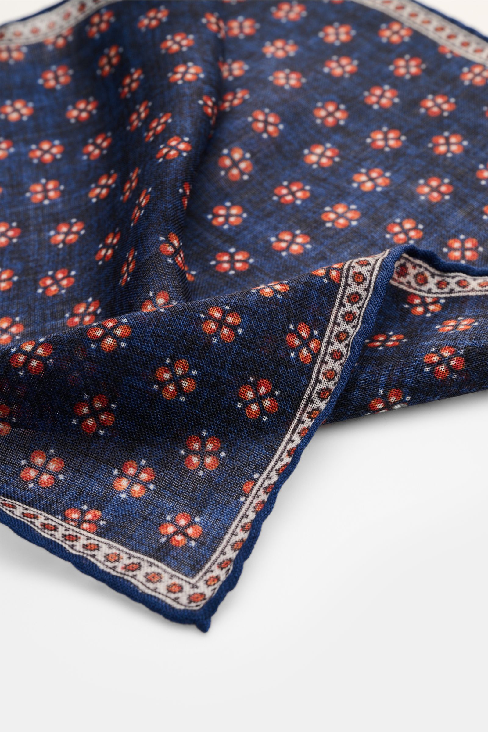 Rosi Collection Einstecktuch 'Ted' dunkelblau meliert/orange/offwhite gemustert, aus reiner Wolle, florales Muster, rollierte Kanten, Nahaufnahme von schräg oben.