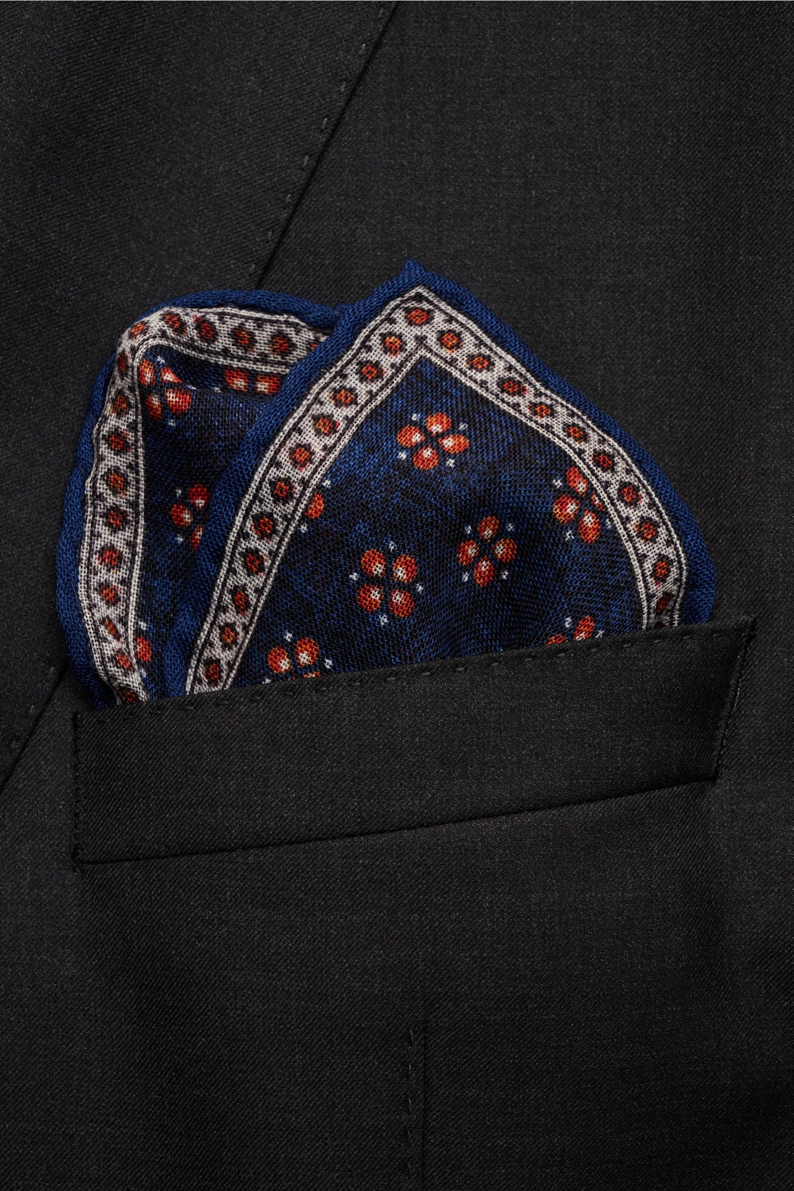 Rosi Collection Einstecktuch 'Ted' dunkelblau meliert/orange/offwhite gemustert, florales Wolltuch mit rollierten Kanten, von oben in Sakko-Brusttasche.