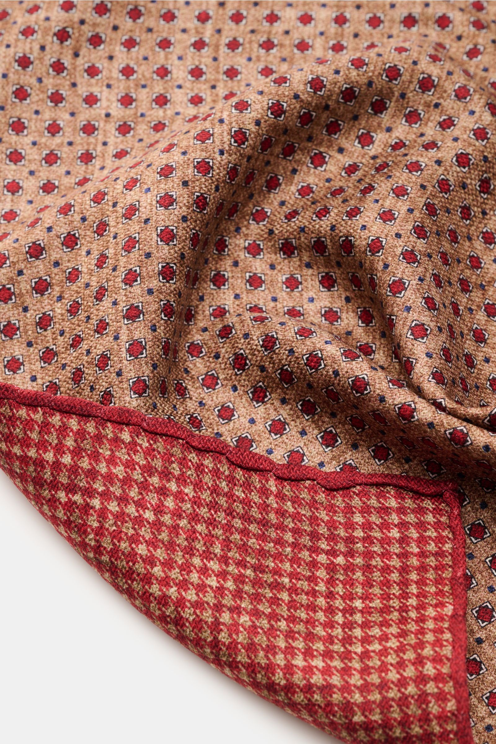 Rosi Collection Einstecktuch 'Easy' rot/hellbraun/weiß gemustert, aus reiner Seide, geometrisch, Rückseite Hahnentritt, rollierte Kanten, Made in Italy, 31x31 cm, Nahaufnahme schräg von oben.