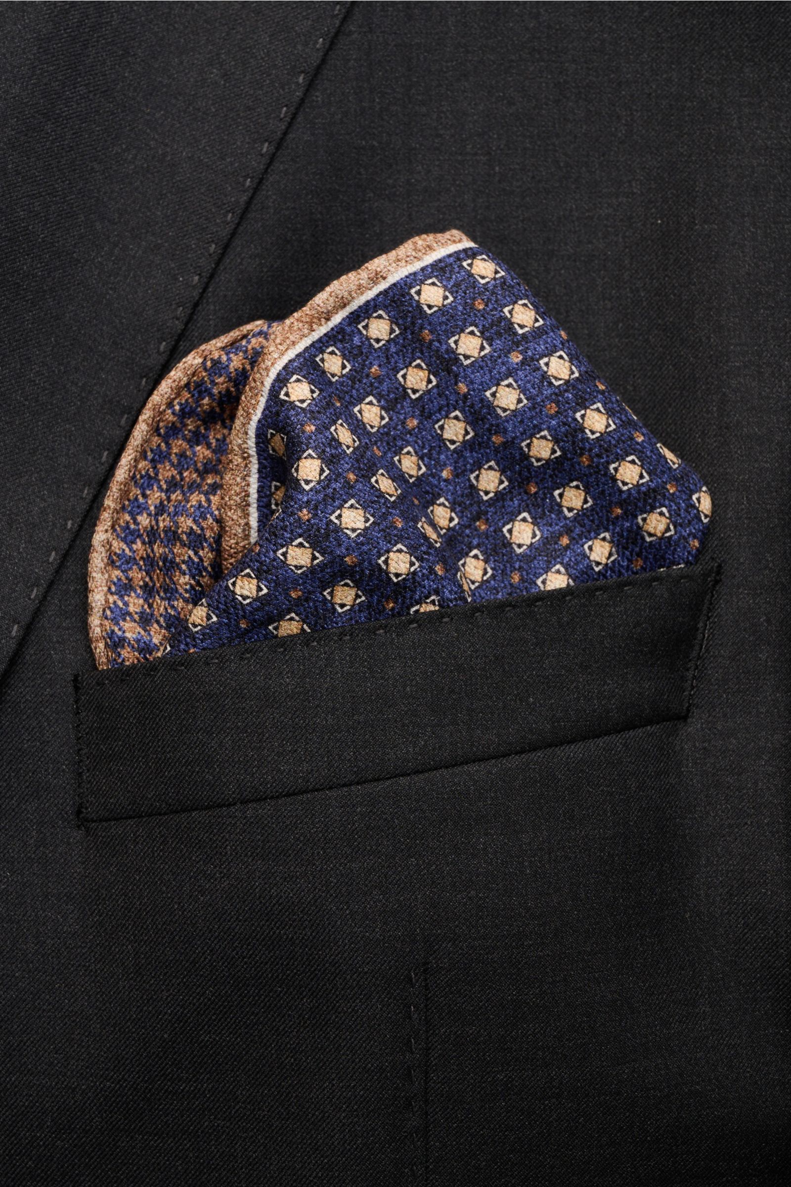Rosi Collection Einstecktuch 'Easy' dunkelblau/hellbraun/weiß gemustert aus reiner Seide mit geometrischem Print, Hahnentritt-Rückseite, rollierte Kanten, ca. 31x31 cm, elegant im Sakko-Brusttaschen-Ausschnitt fotografiert.