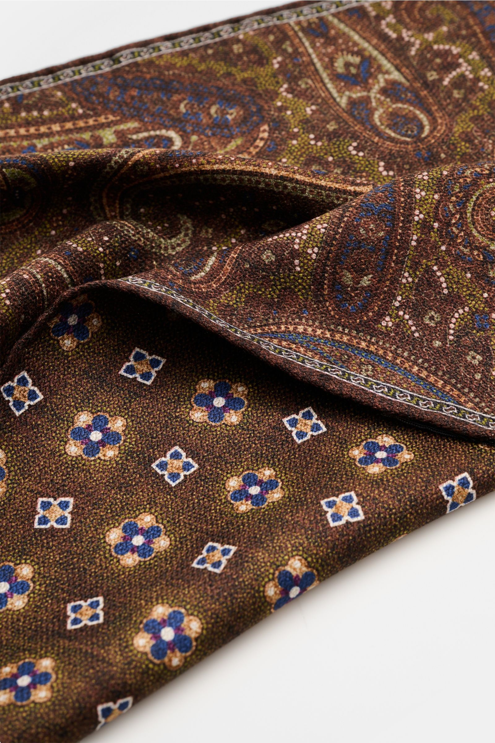 Rosi Collection Seiden-Einstecktuch 'Easy' dunkelbraun/oliv/blau gemustert, Paisley-Muster mit Borte, Medaillon-Rückseite, reine Seide, handrollierte Kanten, 31x31 cm, Made in Italy, weiche, geschmeidige Oberfläche, liegend fotografiert.