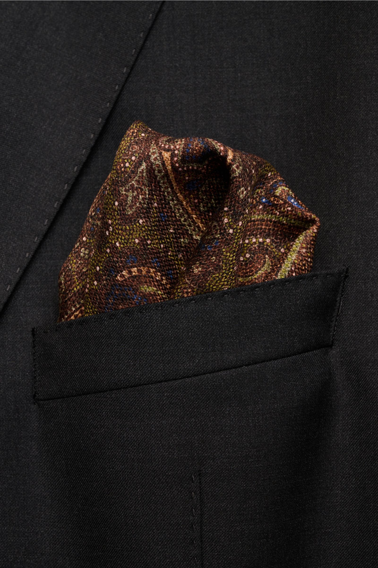 Rosi Collection Silk pocket square 'Easy' dark brown/olive/blue patterned paisley with medallion back, hand-rolled edges, pure silk, soft touch, 31x31 cm, made in Italy, photo from front pocket angle.