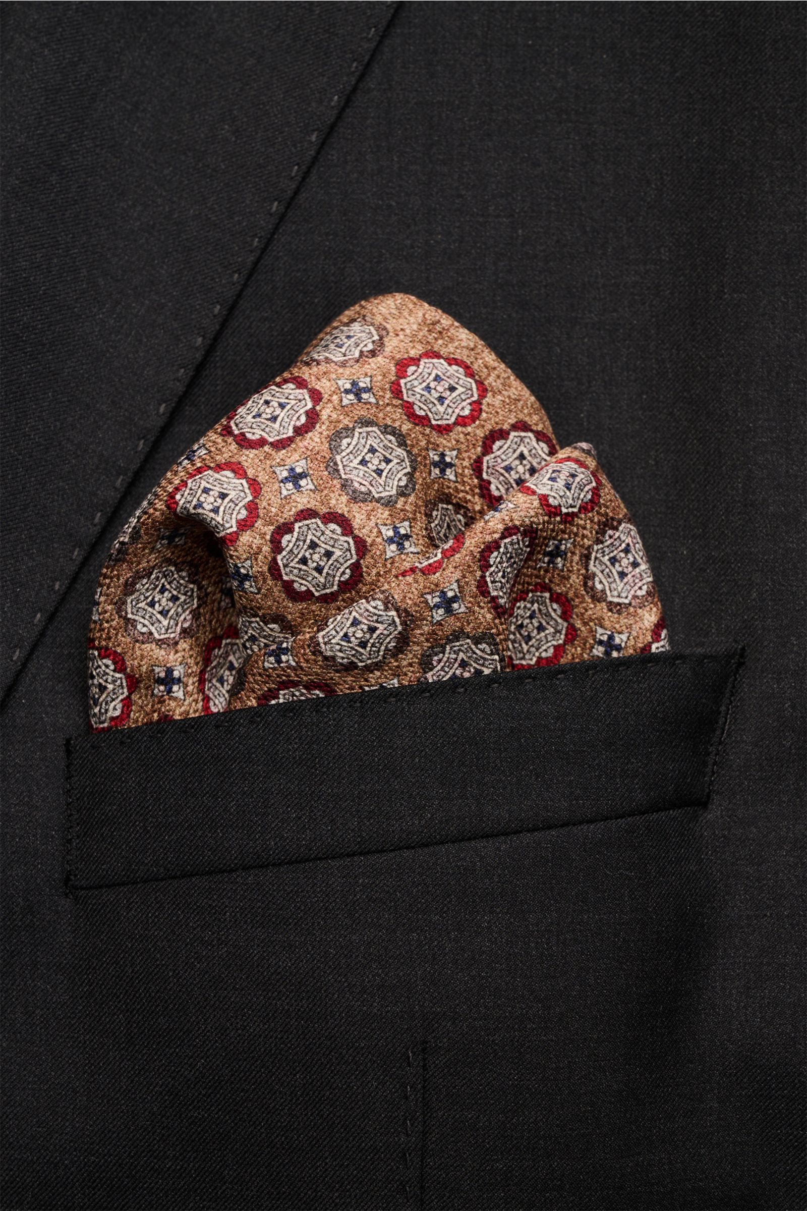 Rosi Collection Seiden-Einstecktuch 'Easy' braun/dunkelbraun/dunkelrot gemustert, reine Seide, Medaillon-Print, Paisley-Rückseite, handrollierte Kanten, soft, ca. 30,5x30,5 cm, Made in Italy, aus Nahaufnahme in schwarzer Jackettasche.