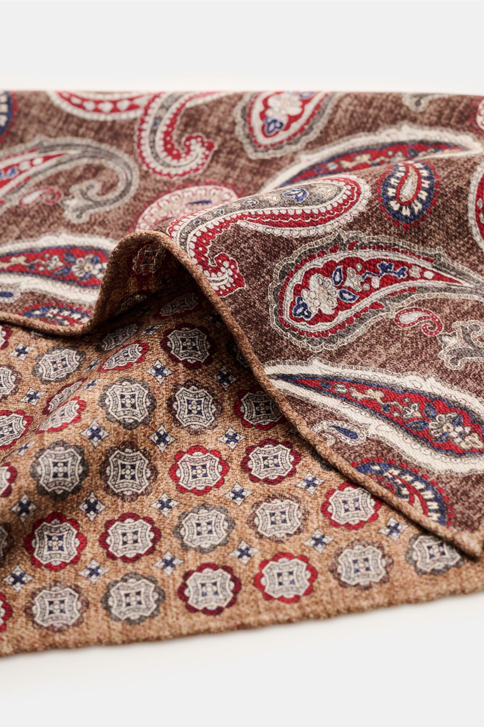 Rosi Collection Seiden-Einstecktuch 'Easy' braun/dunkelbraun/dunkelrot gemustert, aus reine Seide, softer Griff, Medaillon-Print, Rückseite Paisley-Muster, handrollierte Kanten, Made in Italy, ca. 30,5x30,5 cm, Nahaufnahme schräg von oben.