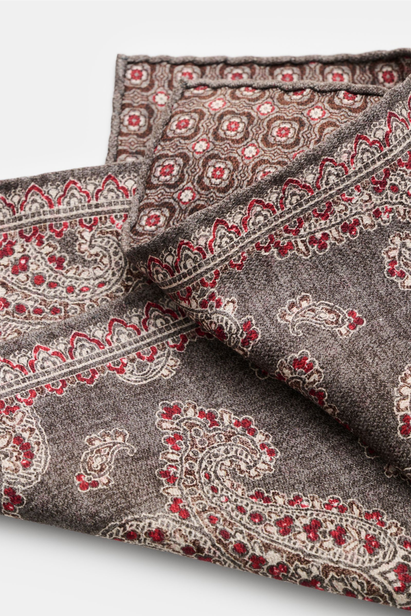 Rosi Collection Seiden-Einstecktuch 'Easy' grau/dunkelrot/dunkelbraun gemustert, Paisley mit Borte, Kachel-Rückseite, reine Seide, 31x31 cm, Made in Italy, rollierte Kanten, weiche, geschmeidige Haptik, Detailaufnahme von oben.
