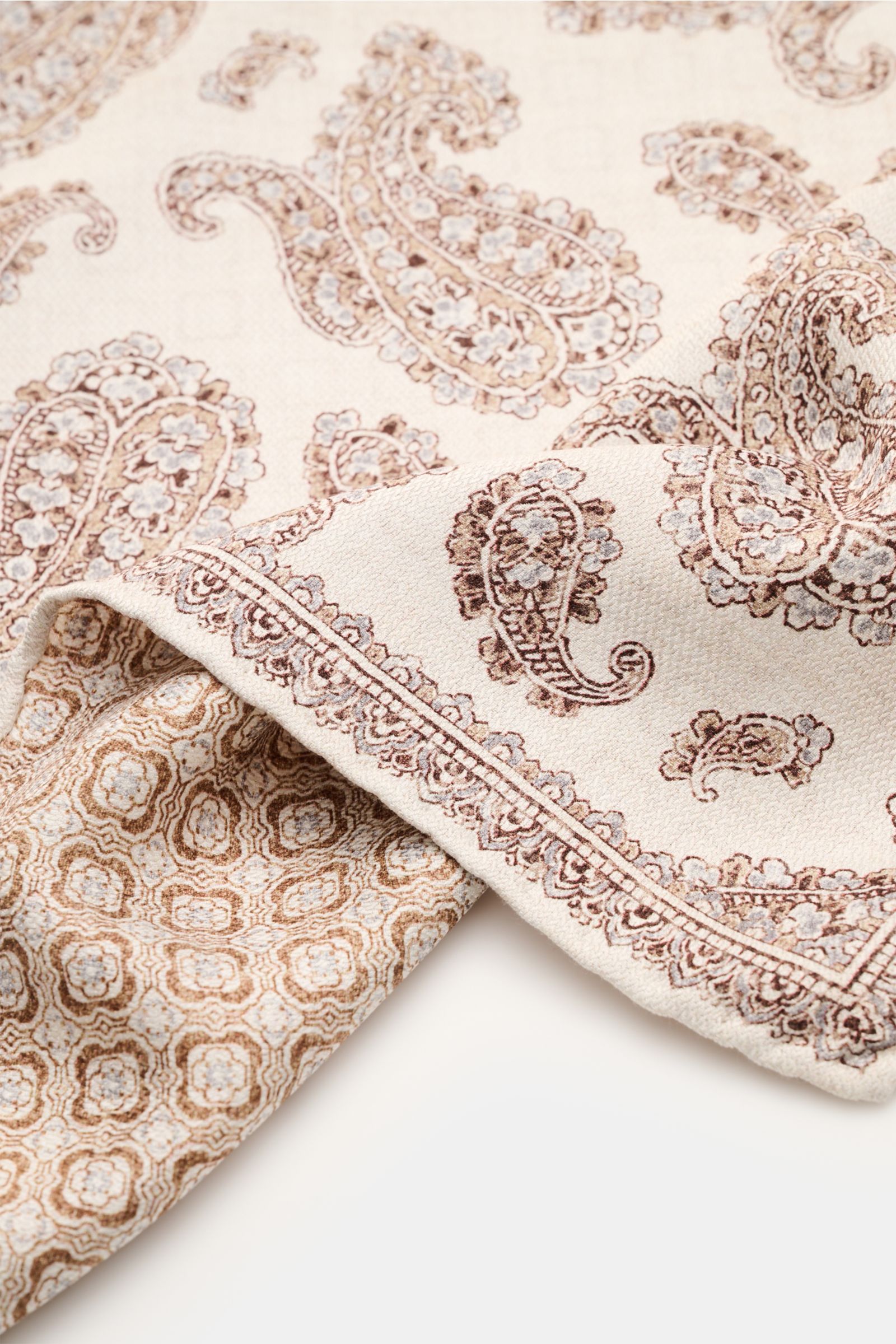 Rosi Collection Seiden-Einstecktuch 'Easy' sand/braun/hellgrau gemustert, reine Seide, Paisley-Muster mit Borte, Rückseite Kachel-Muster, rollierte Kanten, soft, 31x31 cm, Made in Italy, Detailaufnahme schräg von oben.
