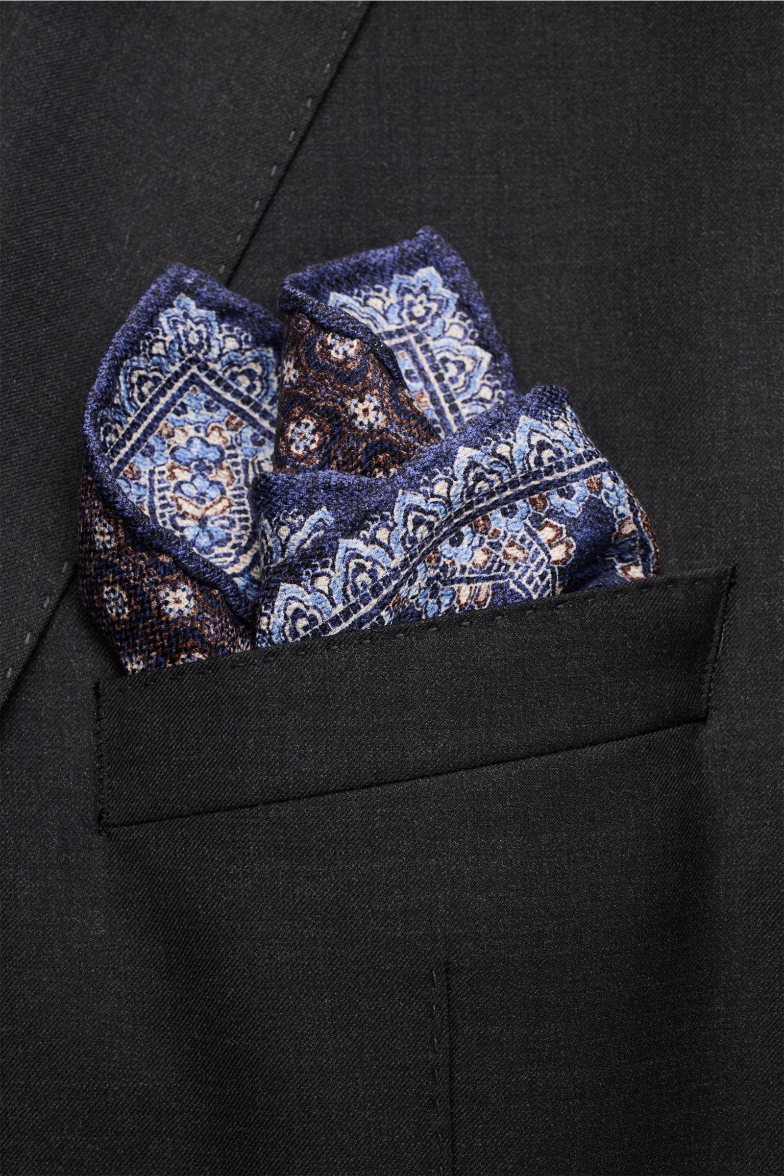 Rosi Collection Seiden-Einstecktuch 'Easy' dunkelblau/dunkelbraun/hellblau gemustert, Paisley-Muster, reine Seide, soft, Kachel-Rückseite, rollierte Kanten, Made in Italy, 31x31 cm, von oben in dunkler Jackettasche.