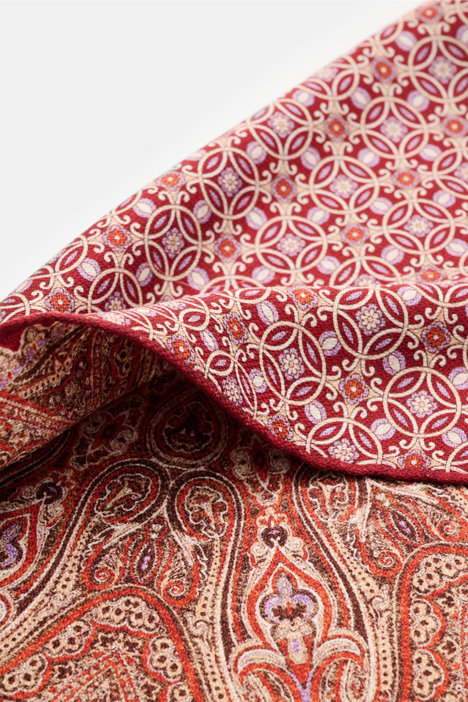 Rosi Collection Einstecktuch 'Easy' rot/orange/beige gemustert, aus reiner Seide mit modernem Paisley-Muster, Vorder- und Rückseite, rollierte Kanten, Detailaufnahme schräg von oben, Made in Italy, ca. 31x31 cm.