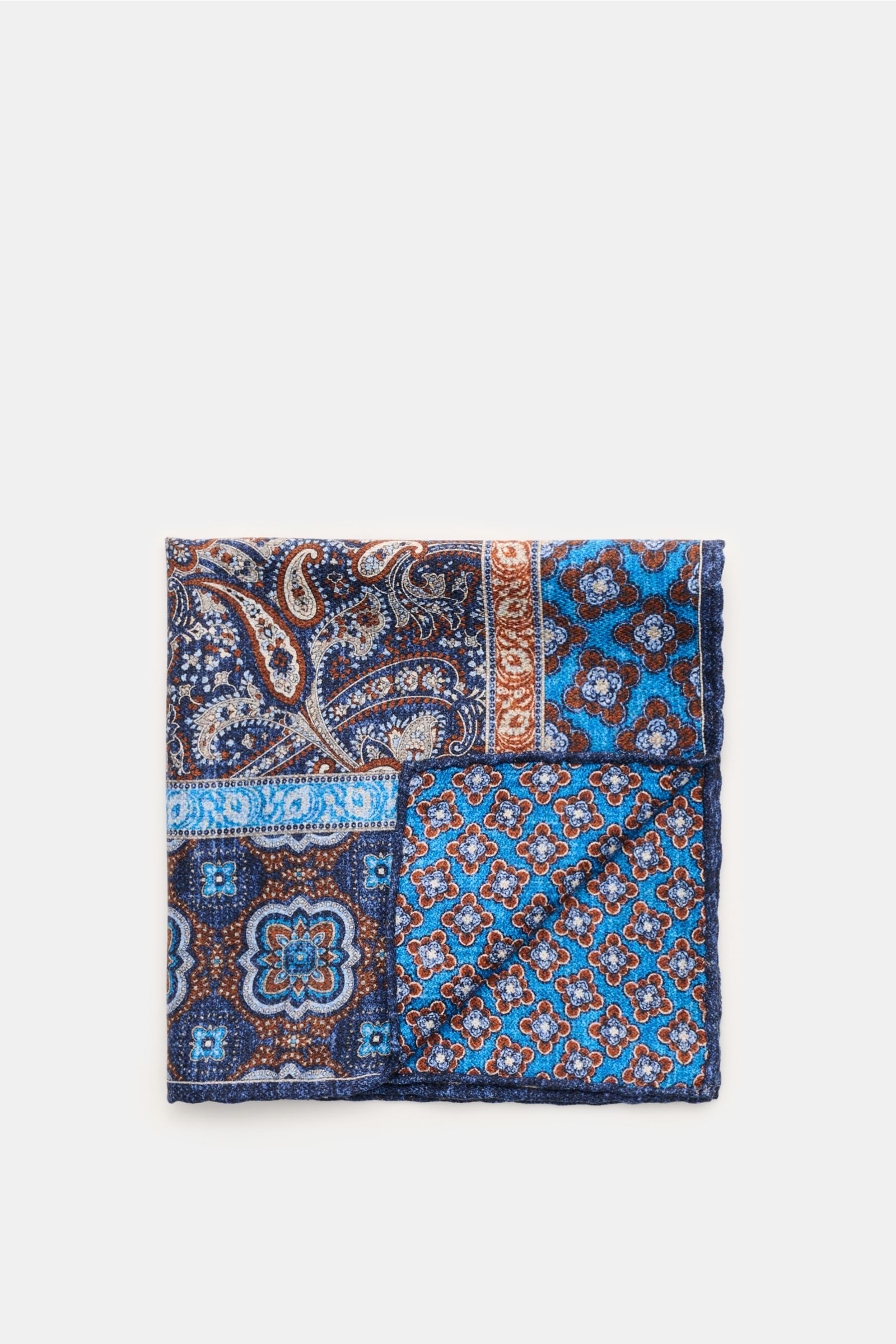 Rosi Collection Seiden-Einstecktuch 'Easy' graublau/blau/braun gemustert, reine Seide, Paisley- und Kachel-Muster, handrollierte Kanten, Maße 31x31 cm, Made in Italy, seitlich fotografiert.