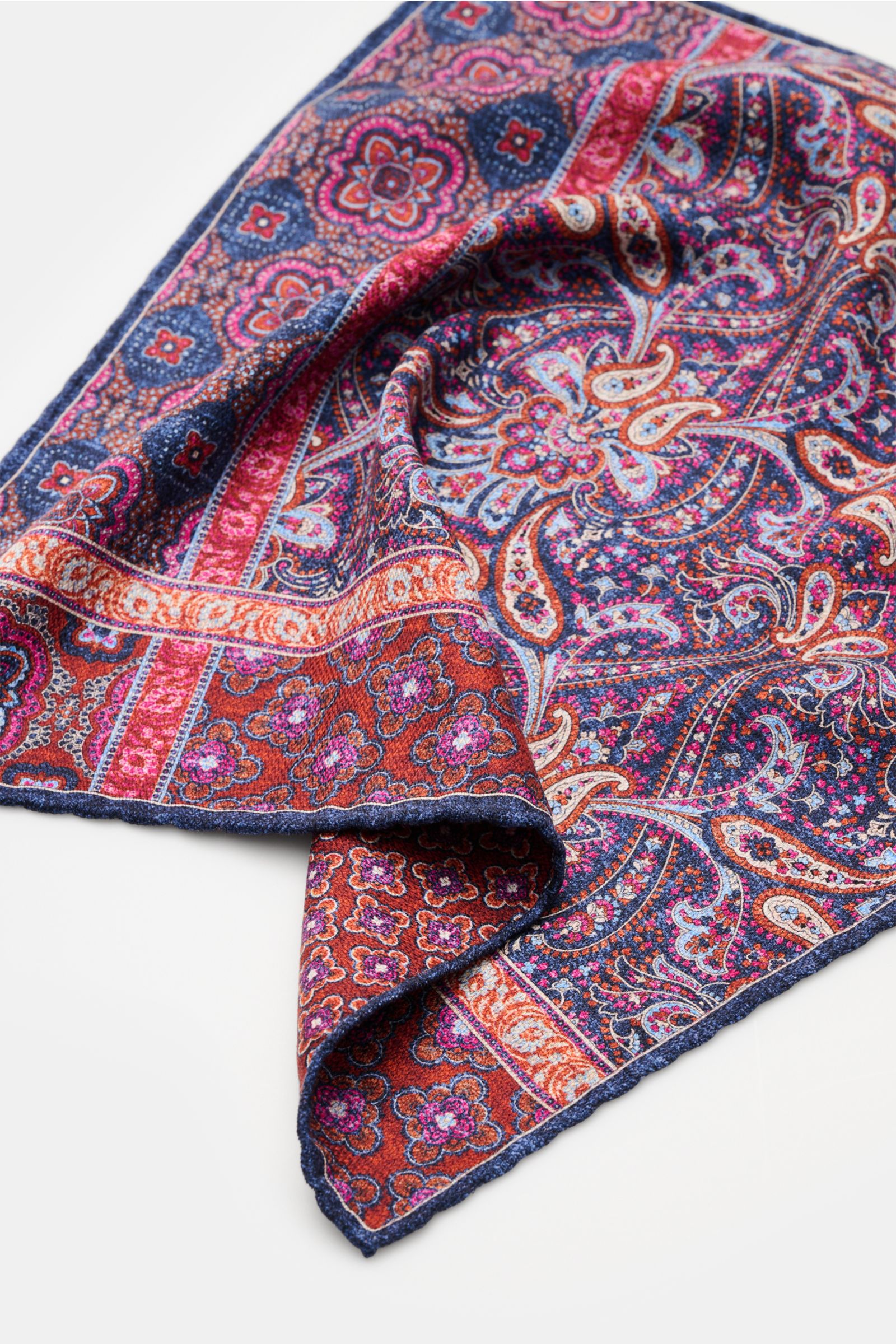 Rosi Collection Seiden-Einstecktuch 'Easy' graublau/rostbraun/violett gemustert, reine Seide, Paisley- und Kachel-Muster, handrollierte Kanten, Maße 31x31 cm, Made in Italy, Perspektive seitlich oben mit sichtbarer Rückseite.