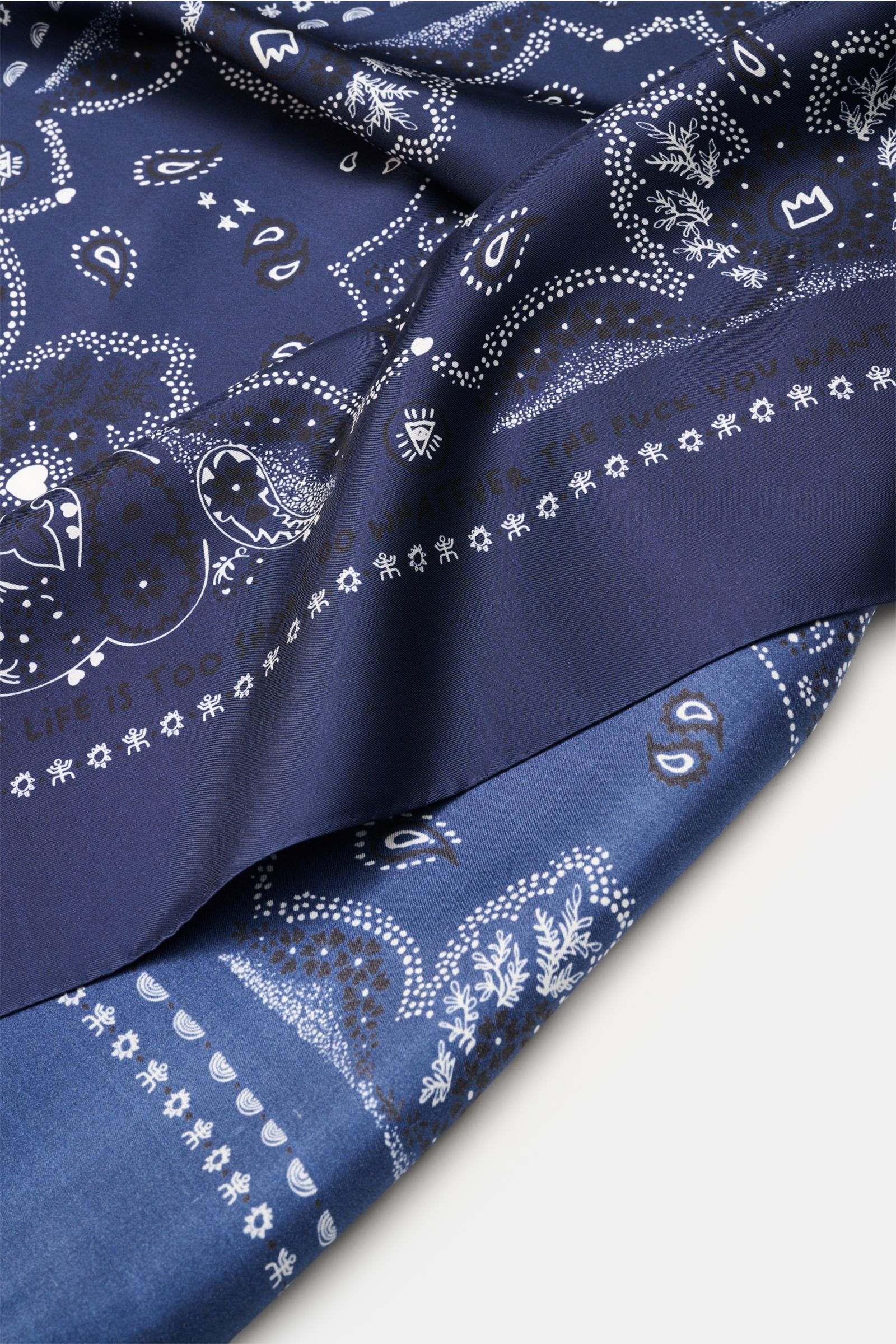 Close-up front view of the Ace Denim Silk scarf navy/black/white patterned folded to show paisley design and smooth texture.

Eye-catching for the warm season: The ACE DENIM silk scarf in a bandana design is a casual statement accessory for summer look