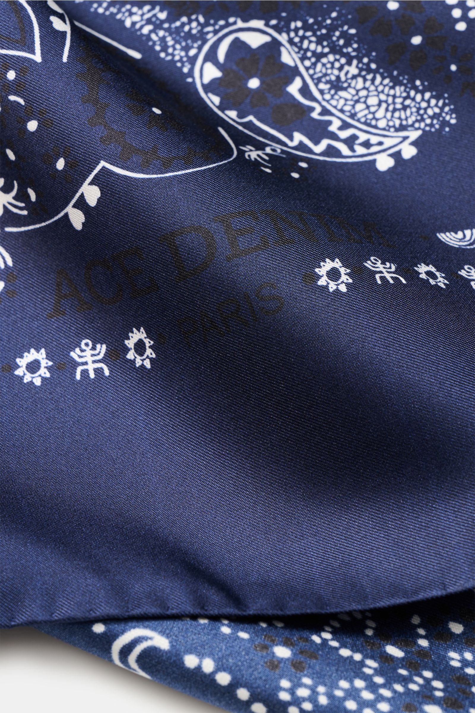 Close-up front view of the Ace Denim Silk scarf navy/black/white patterned showing detailed paisley and floral motifs on smooth silk fabric.

Eye-catching for the warm season: The ACE DENIM silk scarf in a bandana design is a casual statement accessory