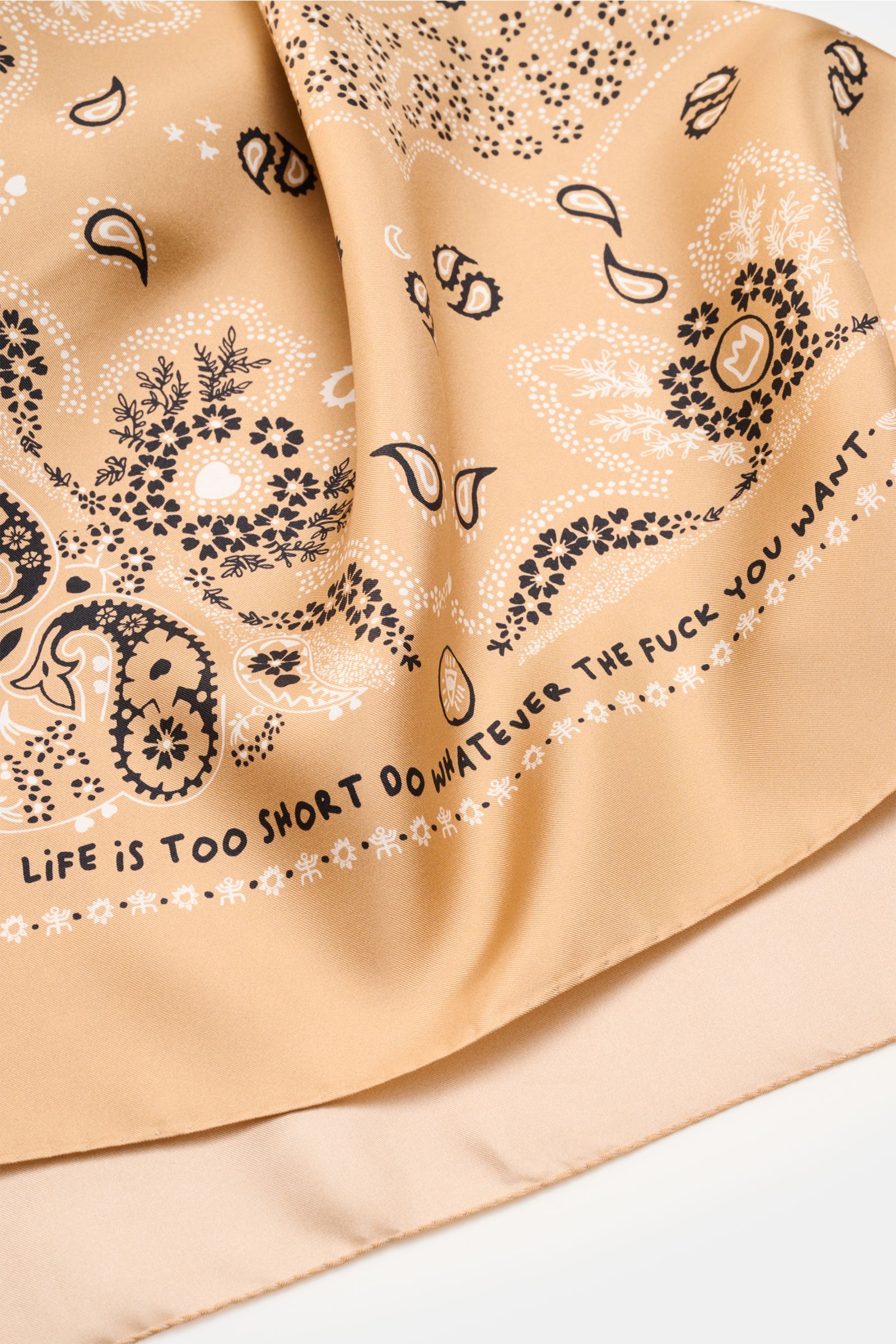 Close-up front view of the Ace Denim Silk scarf light brown/black/white patterned with paisley design, soft pure silk fabric.

Eye-catching for the warm season: The ACE DENIM silk scarf in a bandana design is a casual statement accessory for summer loo