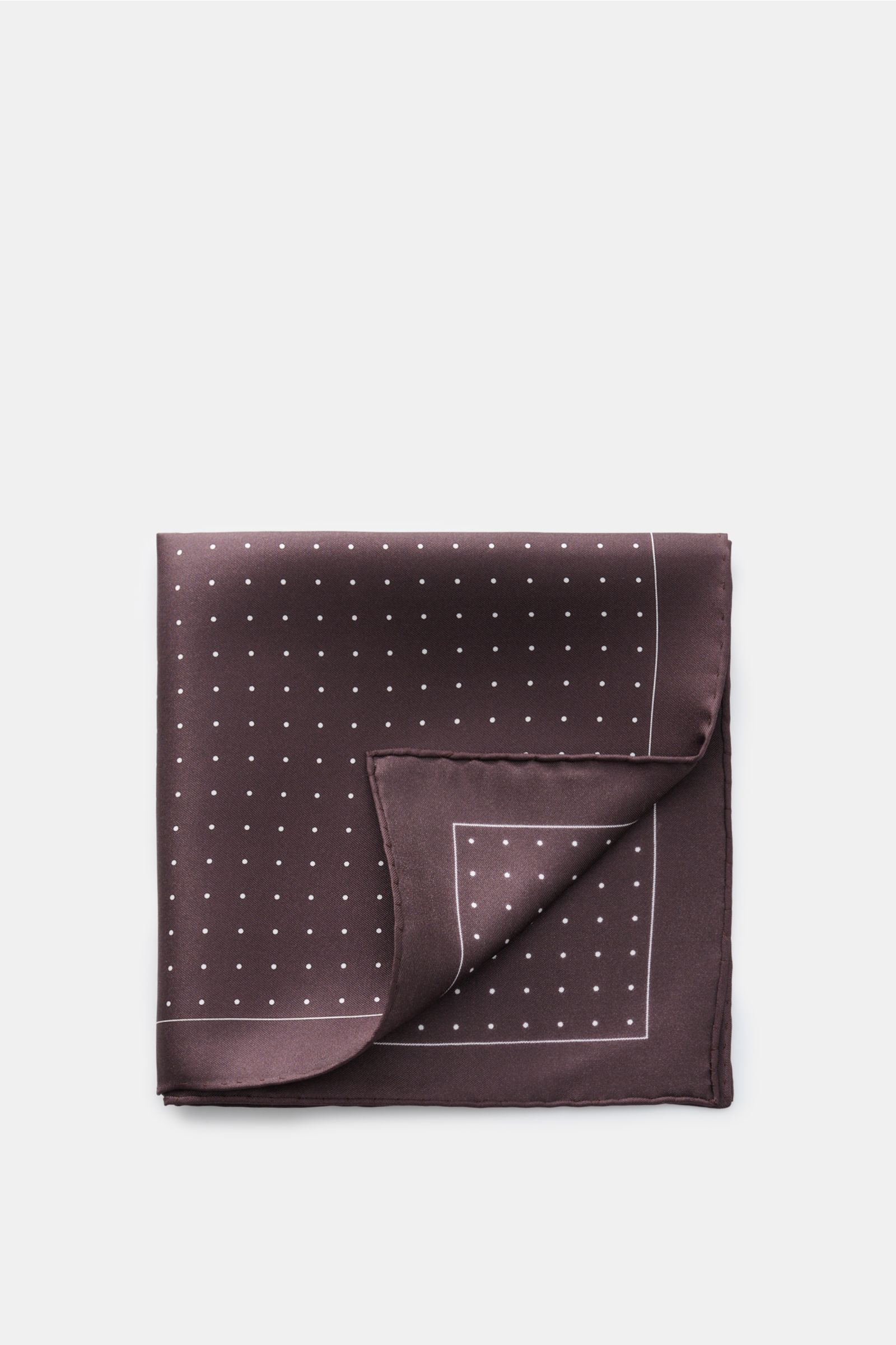 Tom Ford Seiden-Einstecktuch dunkelbraun/weiß gepunktet, folded silk pocket square with small white dots and rolled edges, top view.

Dieses Einstecktuch von TOM FORD aus reiner Seide setzt mit seinem dezenten Punktmuster und den rollierten Kanten ein 